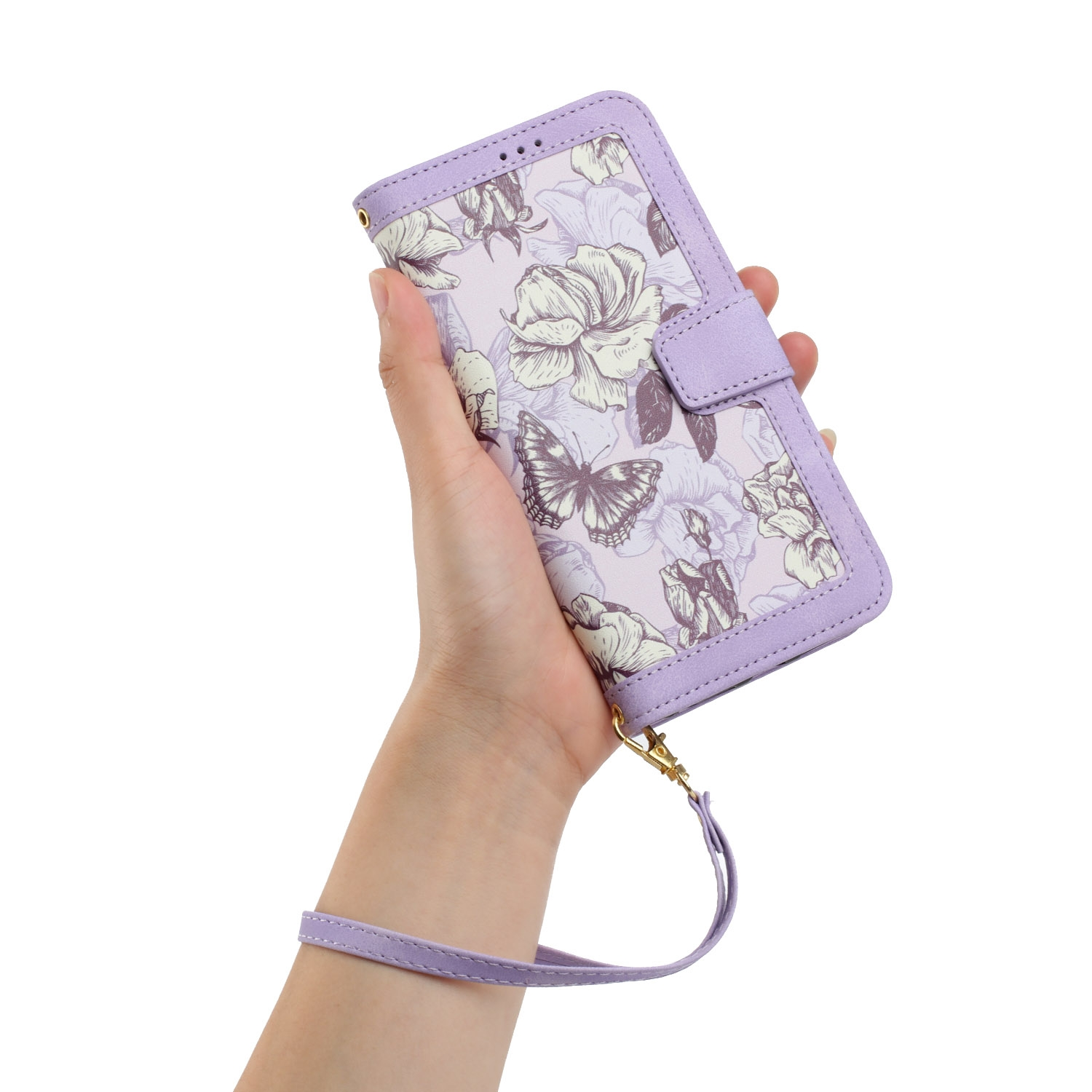 Mano sosteniendo funda morada con flores. Funda cerrada, con correa de muñeca y diseño de mariposa.