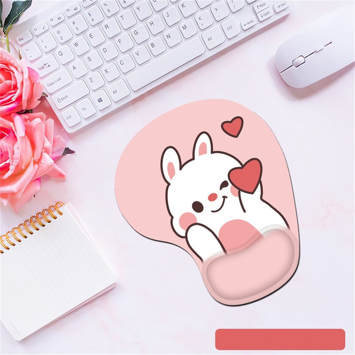 Rosa Mauspad mit Cartoon-Kaninchen, das ein Herz hält, in der Nähe von Tastatur und Maus.