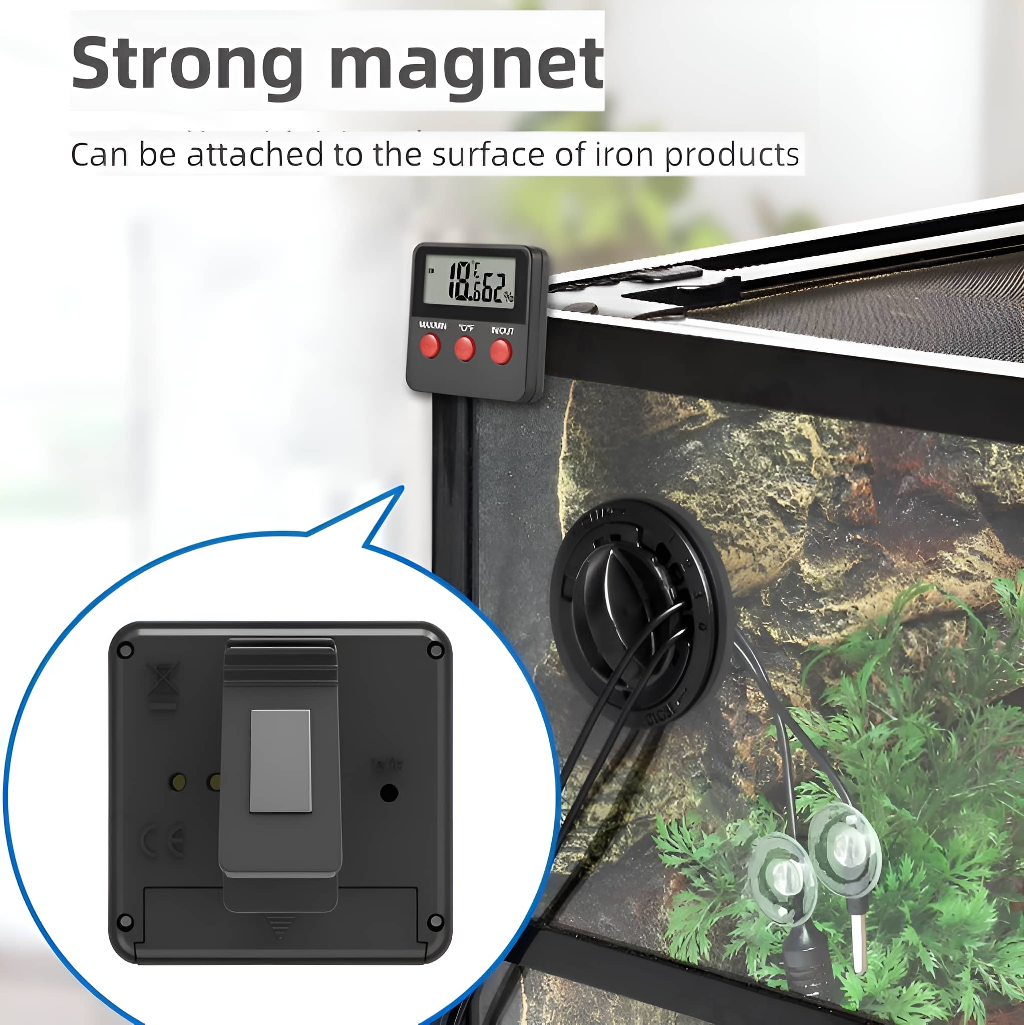 Schwarzes digitales Thermometer mit roten Knöpfen an einem Terrarium.