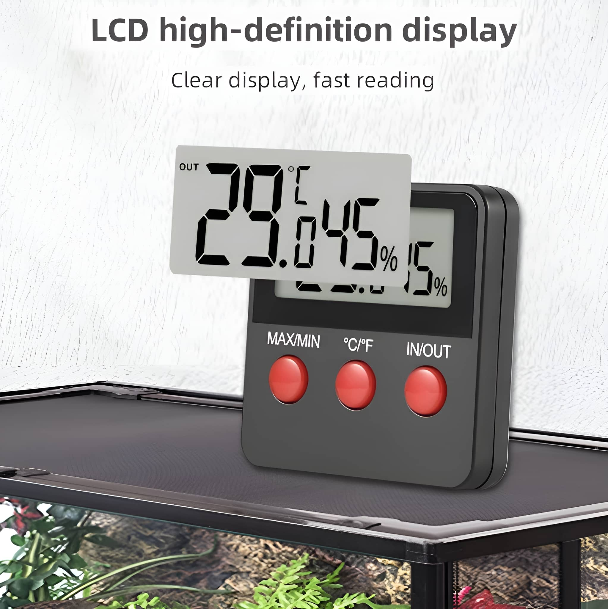 Digitales Thermometer mit 29,645% und andere Messwerte. Es befindet sich neben einem Terrarium.