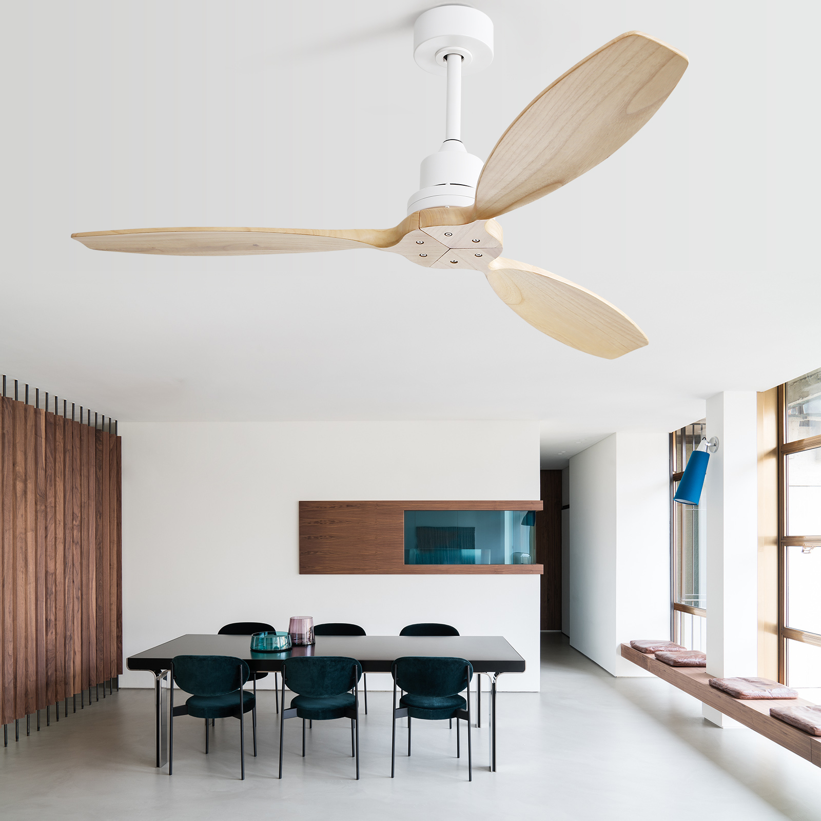 Ein weißer Deckenventilator mit Holzflügeln befindet sich über einem Esstisch mit Stühlen. Der Raum ist hell beleuchtet.