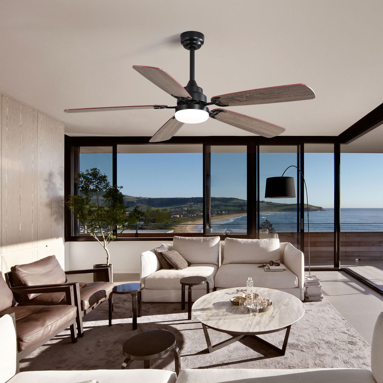 Deckenventilator mit Holzblättern und schwarzem Motor, in einem Wohnzimmer mit Meerblick.