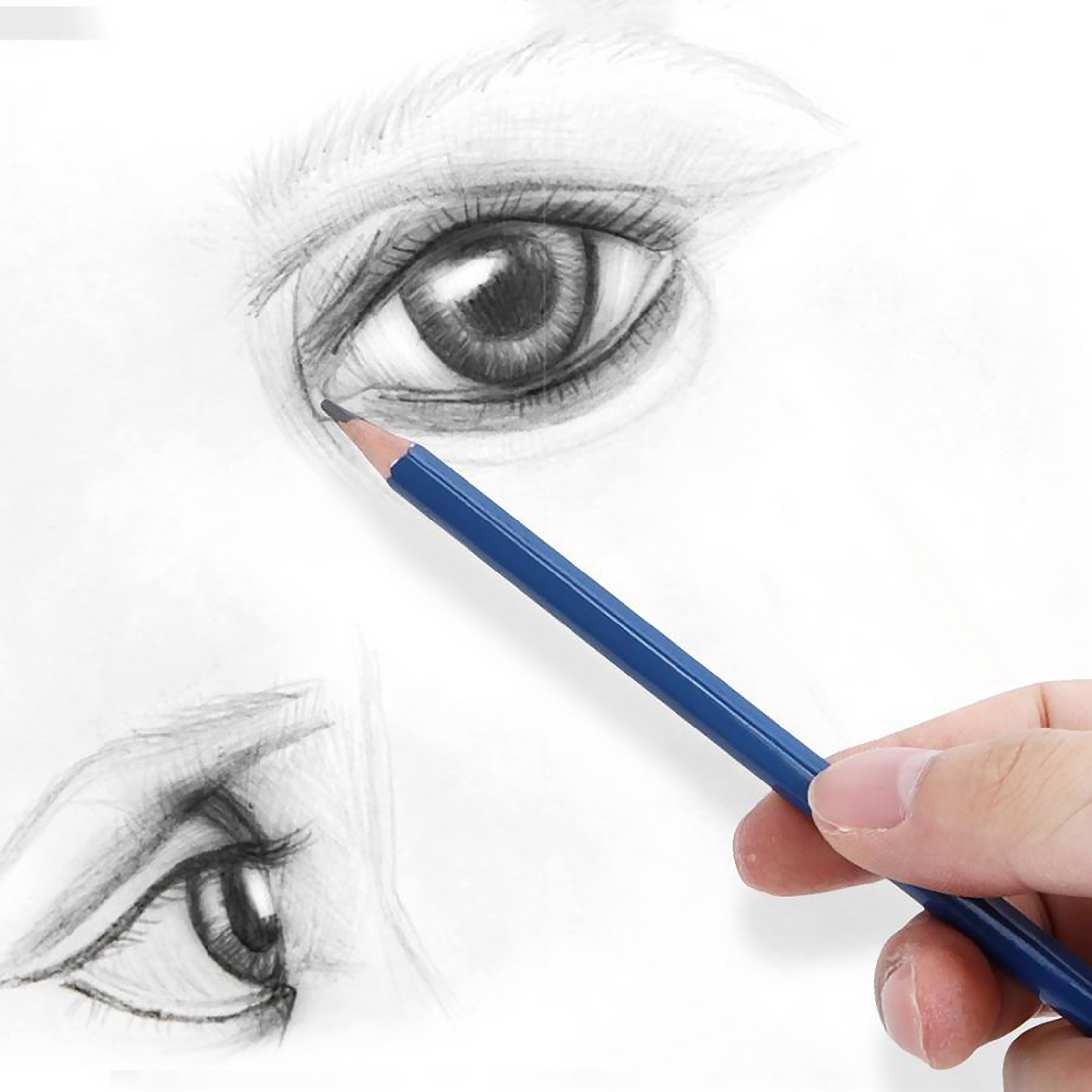 Hand hält einen blauen Bleistift, zeichnet ein Auge auf weißem Papier. Eine weitere Augenskizze sichtbar.
