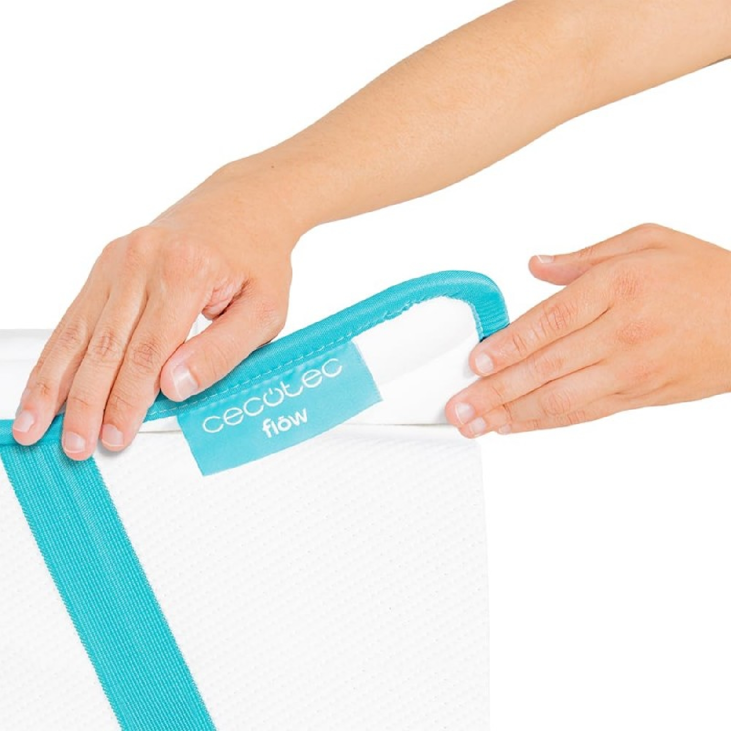 Manos colocando una etiqueta turquesa en un colchón blanco.