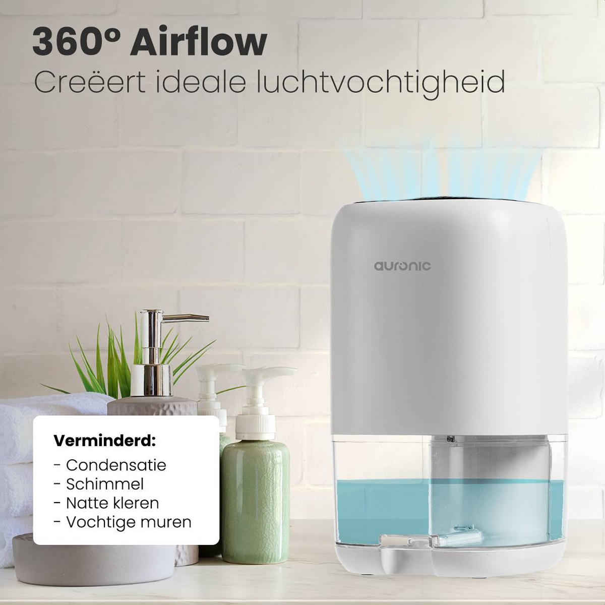 Witte luchtontvochtiger met watertank en plant, naast handdoek en zeep.