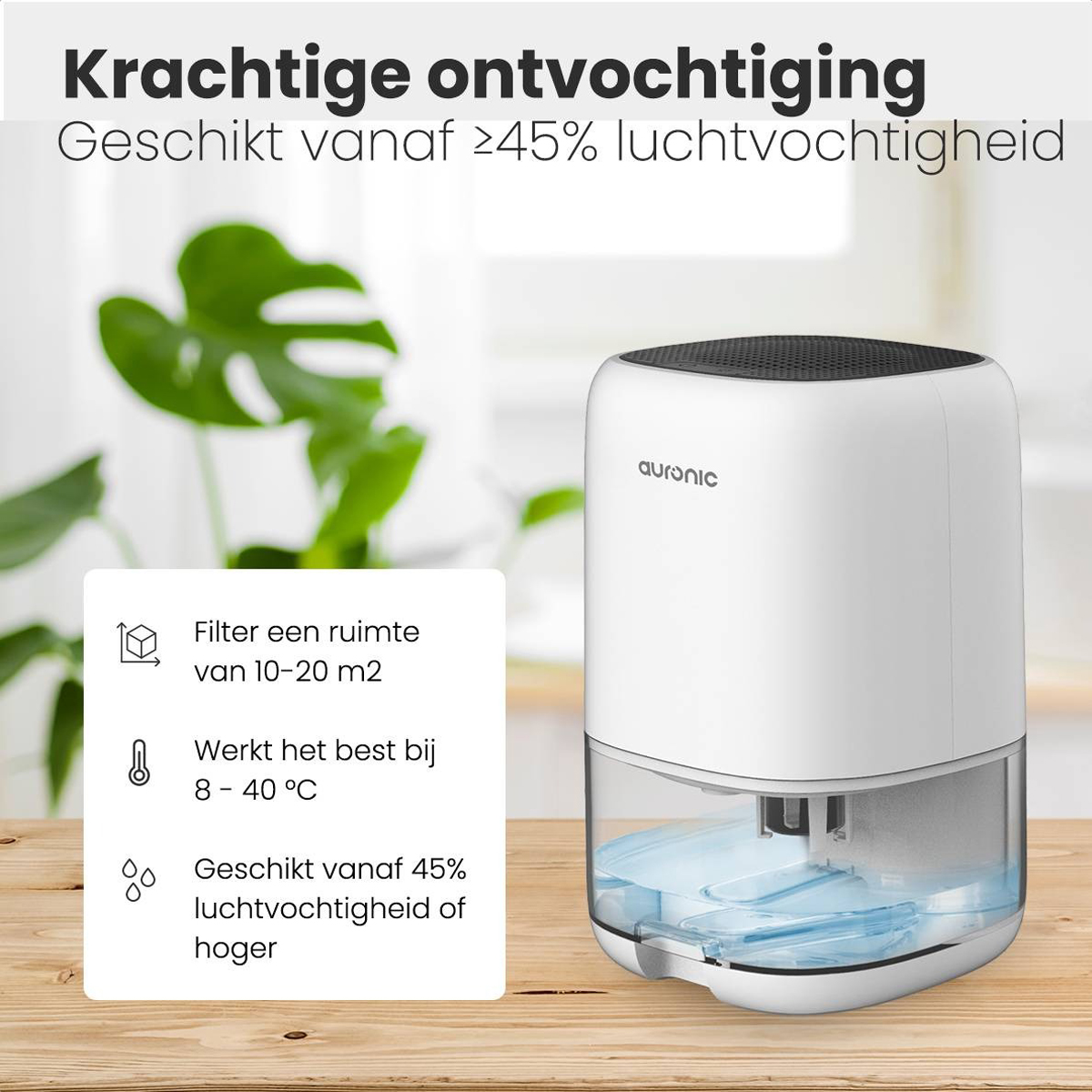 Witte luchtontvochtiger op houten tafel. Tekst links en boven. Achtergrond toont een plant.