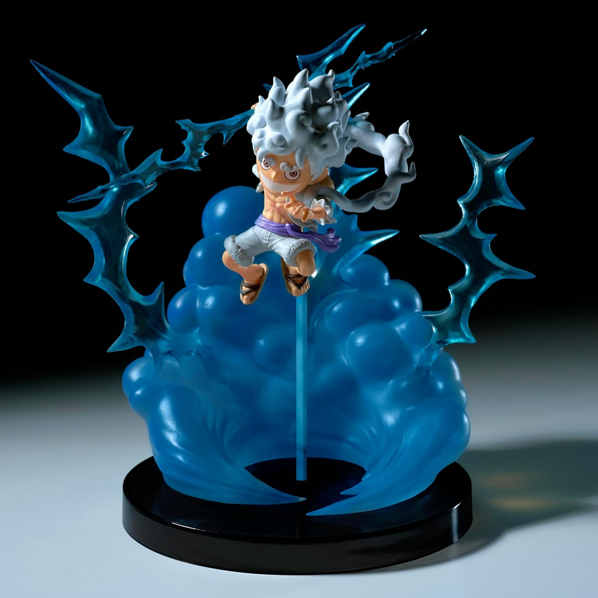 Figura de anime de un personaje de dibujos animados sobre efecto azul energético.