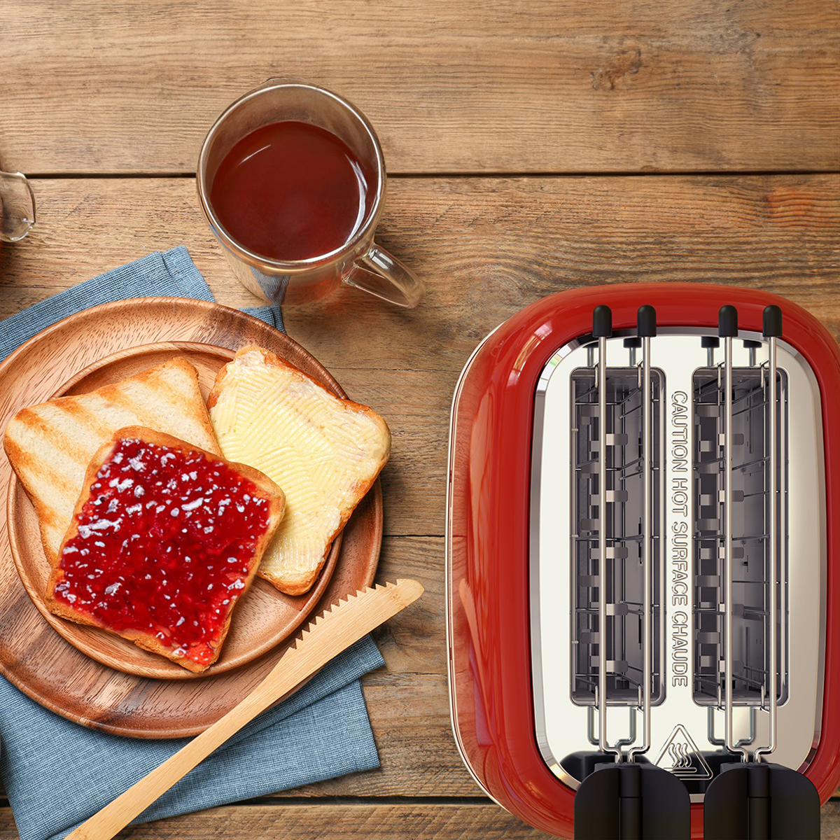 Scène du petit-déjeuner : toasts avec confiture et beurre, thé en tasse et grille-pain rouge.