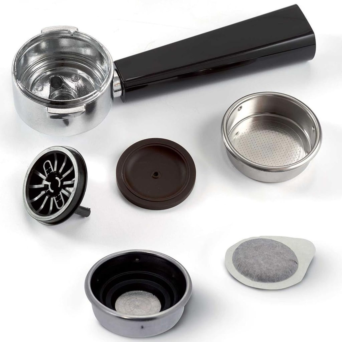 Elementy ekspresu do kawy: kolba, filtry, krążki i uchwyt, ułożone na powierzchni.