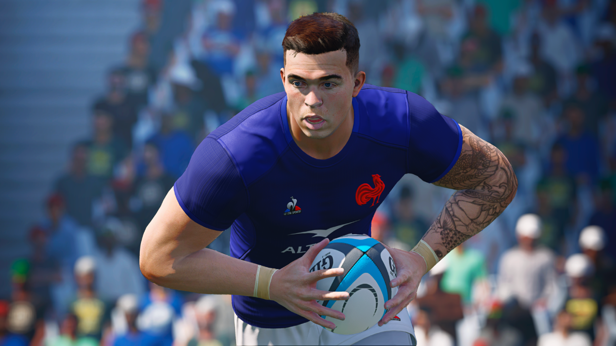 Jugador de rugby con camiseta azul sostiene balón, tatuaje en brazo, multitud atrás.