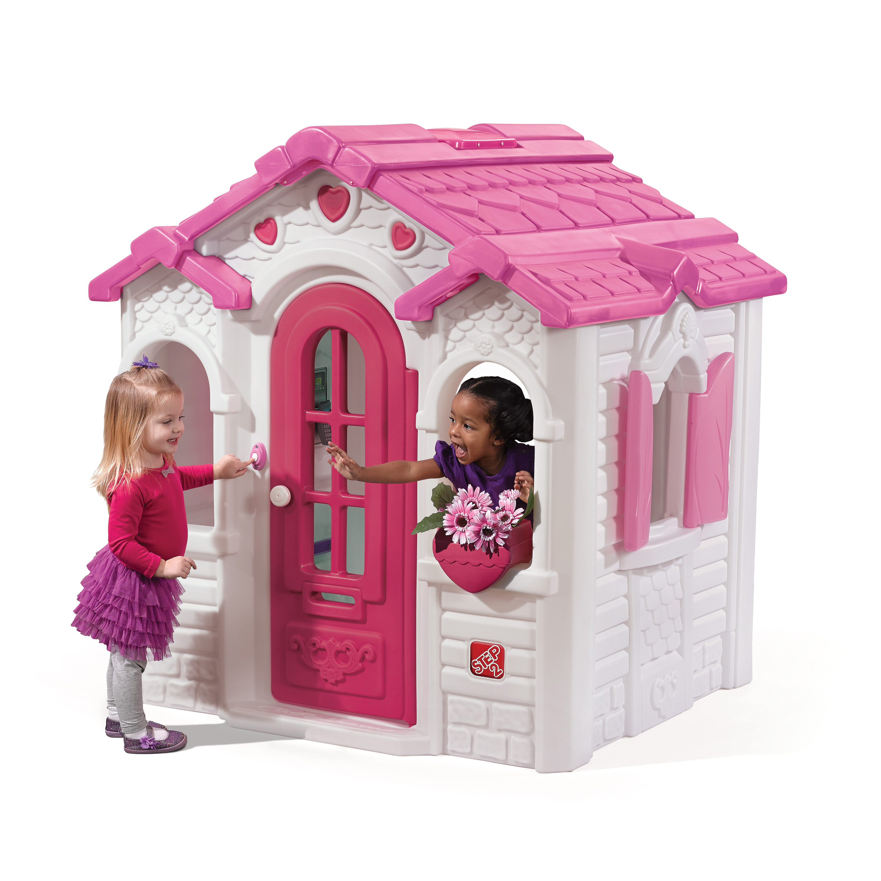 Zwei Kinder spielen in einem rosa-weißen Spielhaus. Eines öffnet die Tür.
