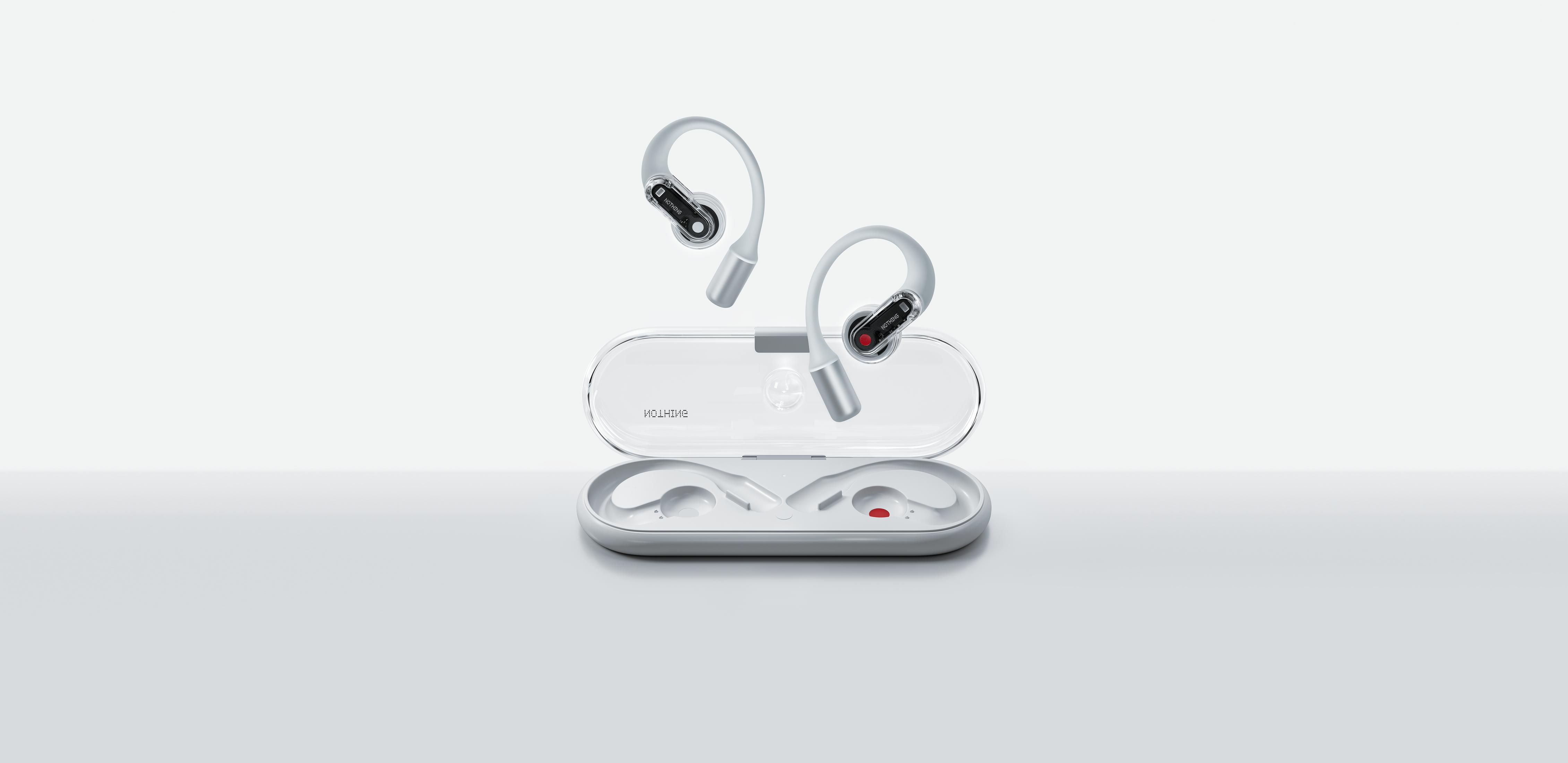 Para białych bezprzewodowych słuchawek i ich etui ładujące, na białej powierzchni.