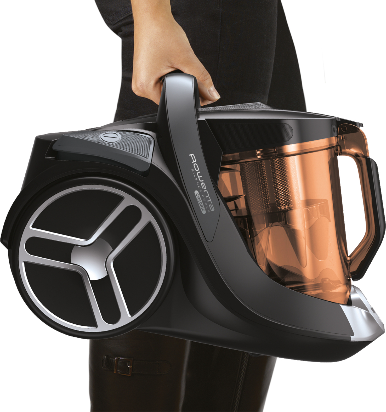 Osoba trzymająca czarny i miedziany odkurzacz.