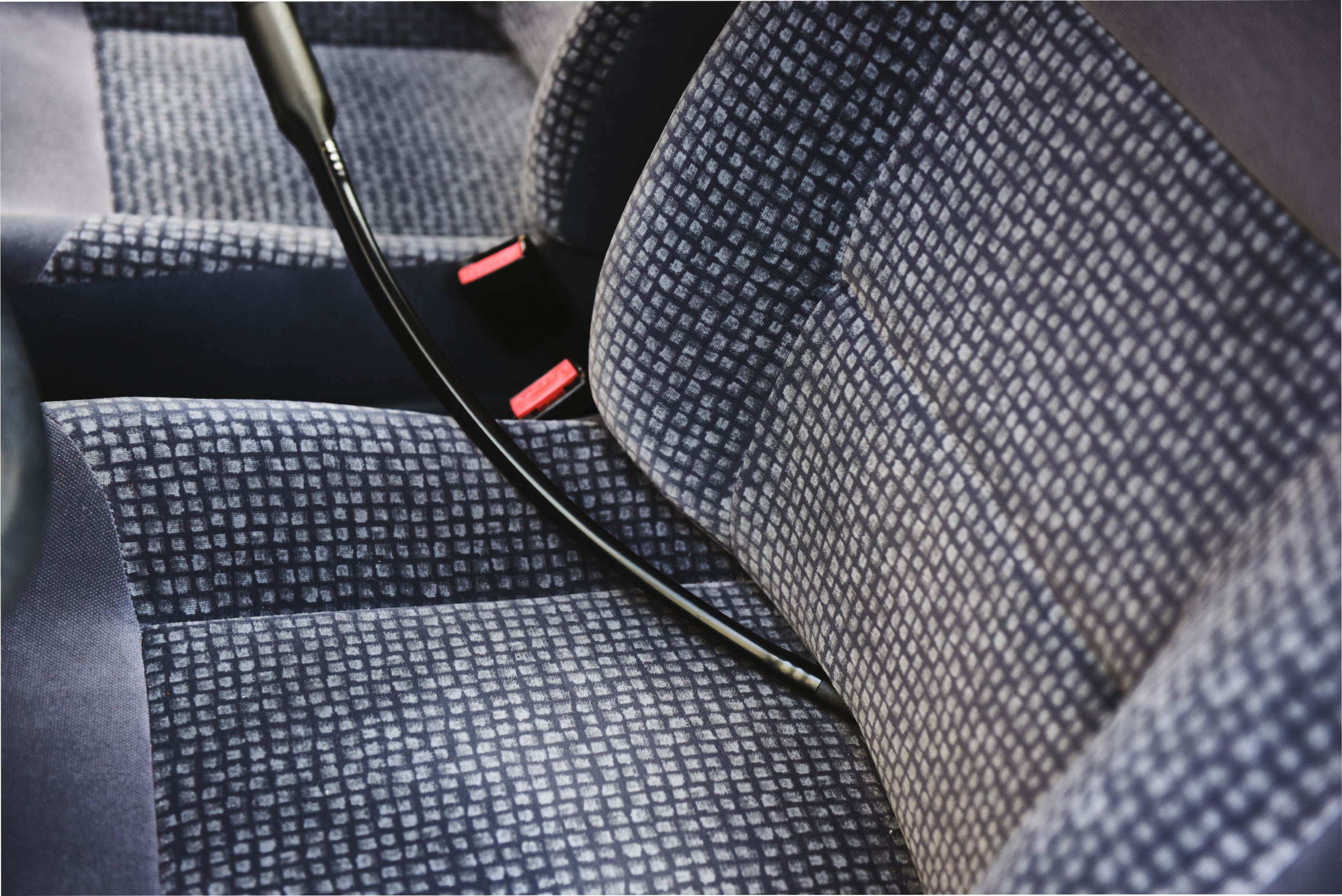 Tapicerka fotela samochodowego, niebieska kraciasta tkanina, zbliżenie.