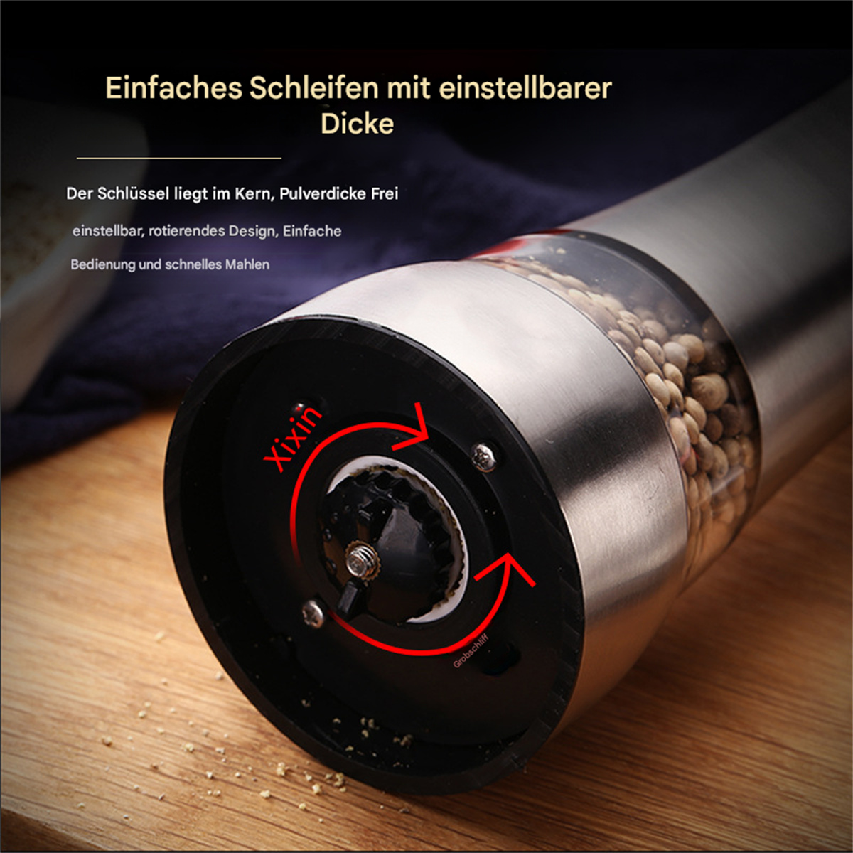 Eine Pfeffermühle mit Glaskörper und silbernem Deckel. Die Mühle steht auf einer Holzoberfläche.