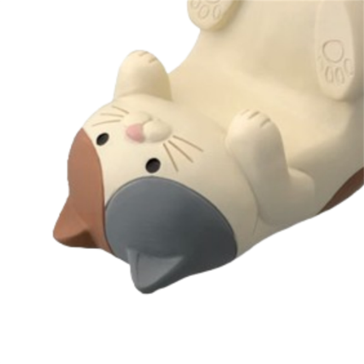 Eine Katzenfigur, die kopfüber liegt, mit ihrem Gesicht sichtbar. Sie hat eine graue Nase und braune Ohren.