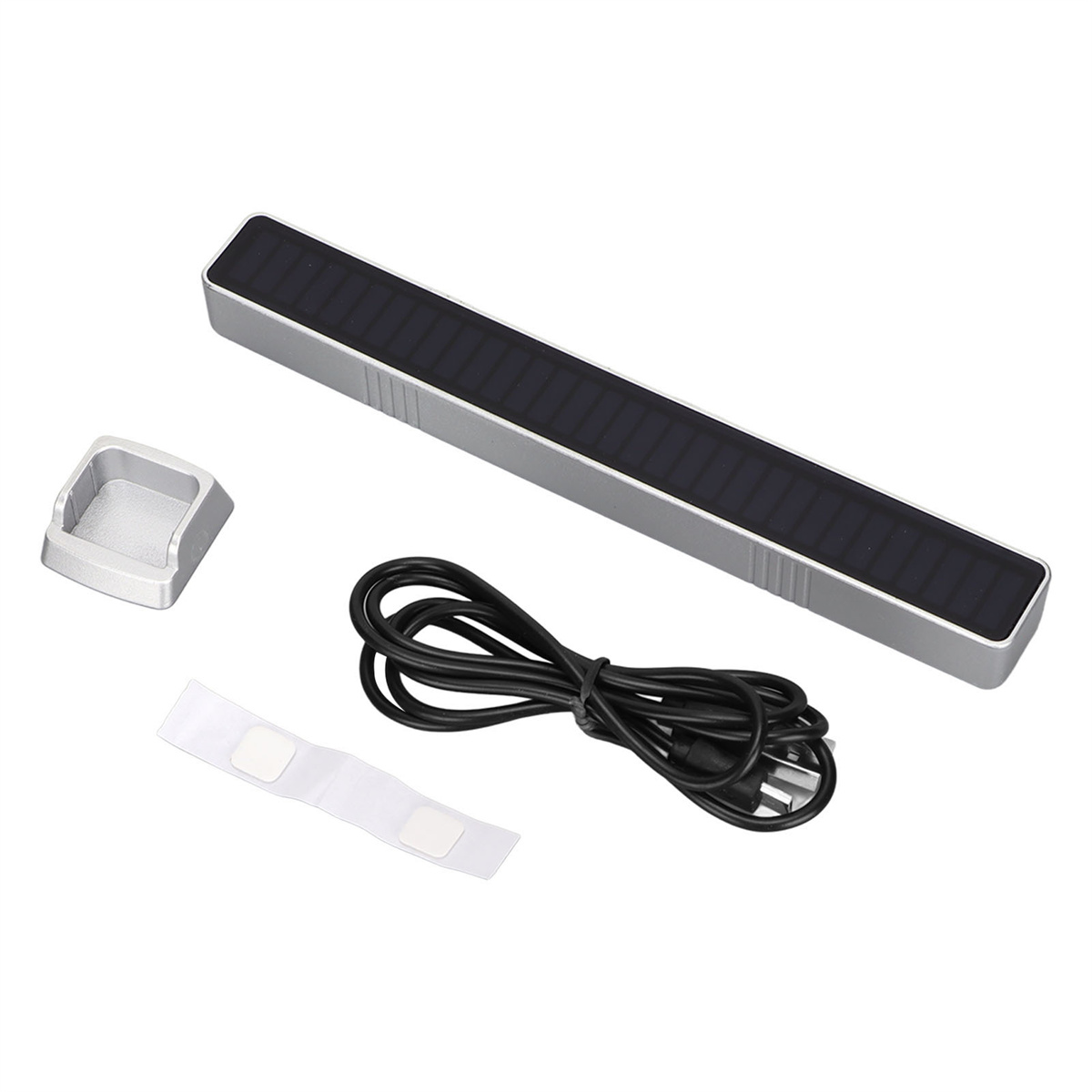 Silberner Balken mit schwarzem Solarpanel, weißem Aufkleber und Kabel. Kleine silberne Basis links.