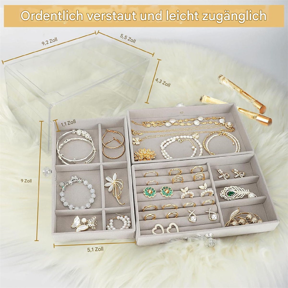 Schmuckorganizer mit durchsichtigem Deckel, enthält Schmuck in Fächern. Weißer Pelz im Hintergrund.