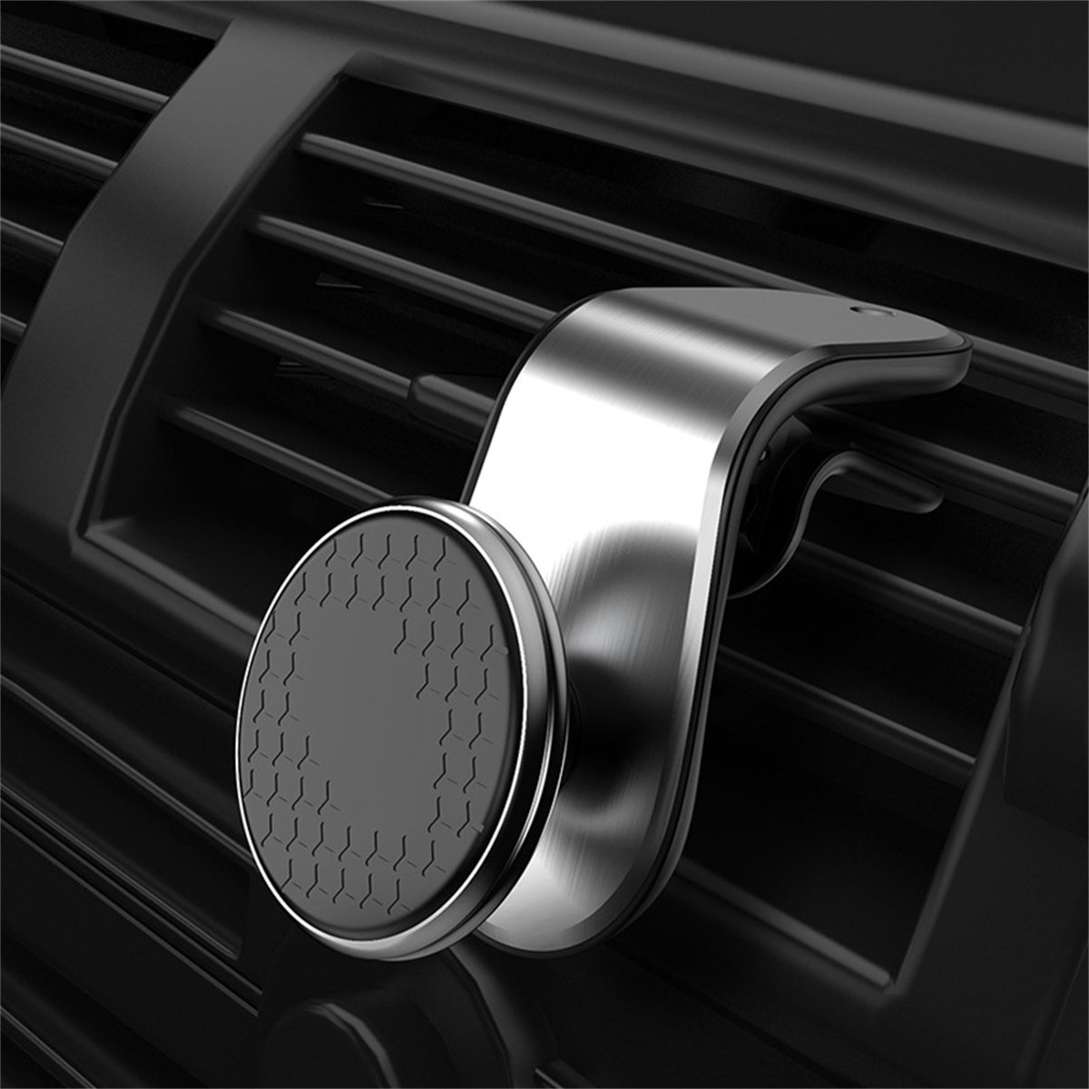 Ein metallischer Handyhalter für die Lüftung im Auto. Er ist silber und schwarz und an einer Lüftung befestigt.