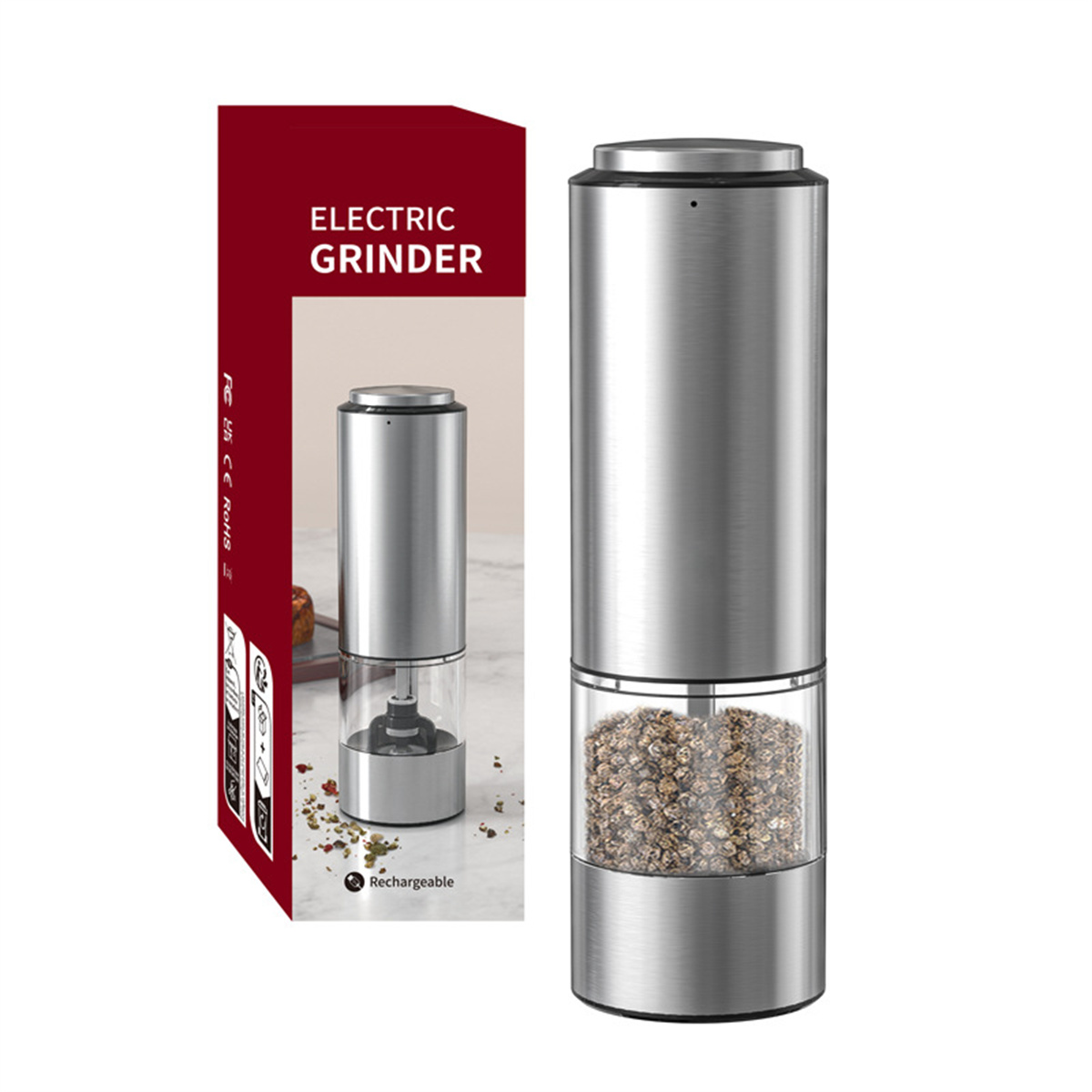 Ein silberner elektrischer Grinder neben einer Box. Der Grinder hat einen Glasteil, der mit Pfefferkörnern gefüllt ist.