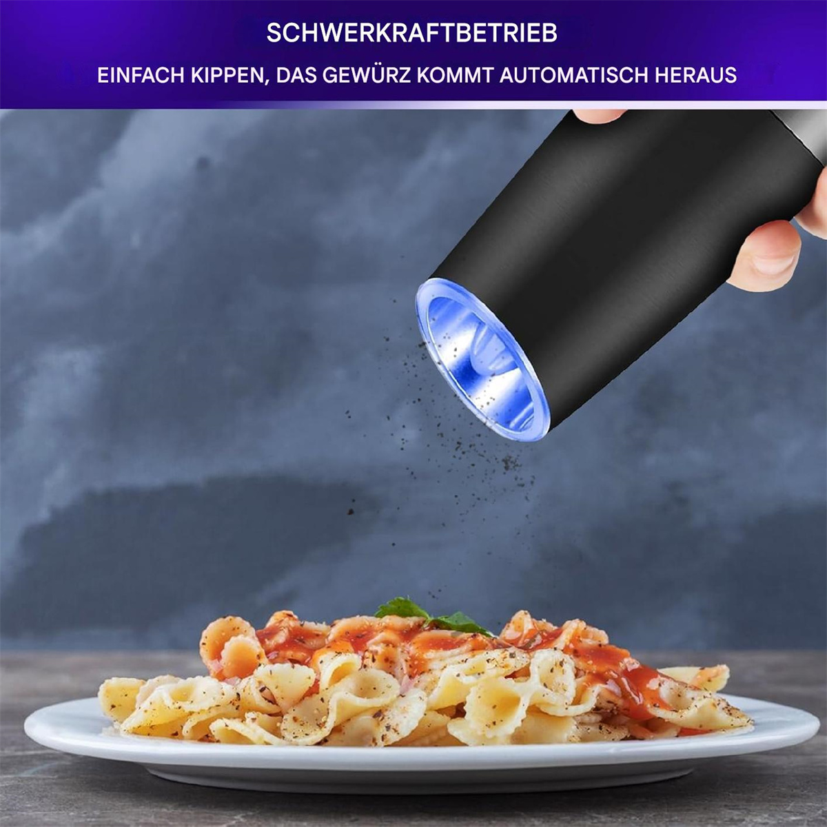 Schwarze elektrische Pfeffermühle, die Pfeffer auf einen Pastateller gibt.