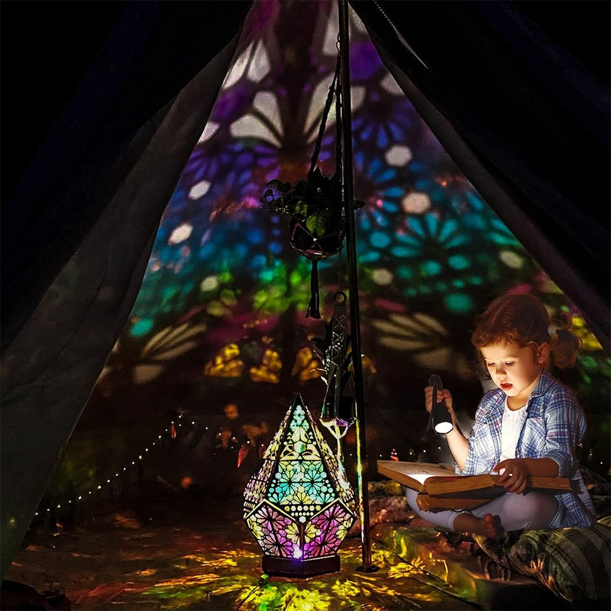 Mädchen liest in einem Zelt mit farbenfroher Lampe und Lichtmustern, dunkle Umgebung.