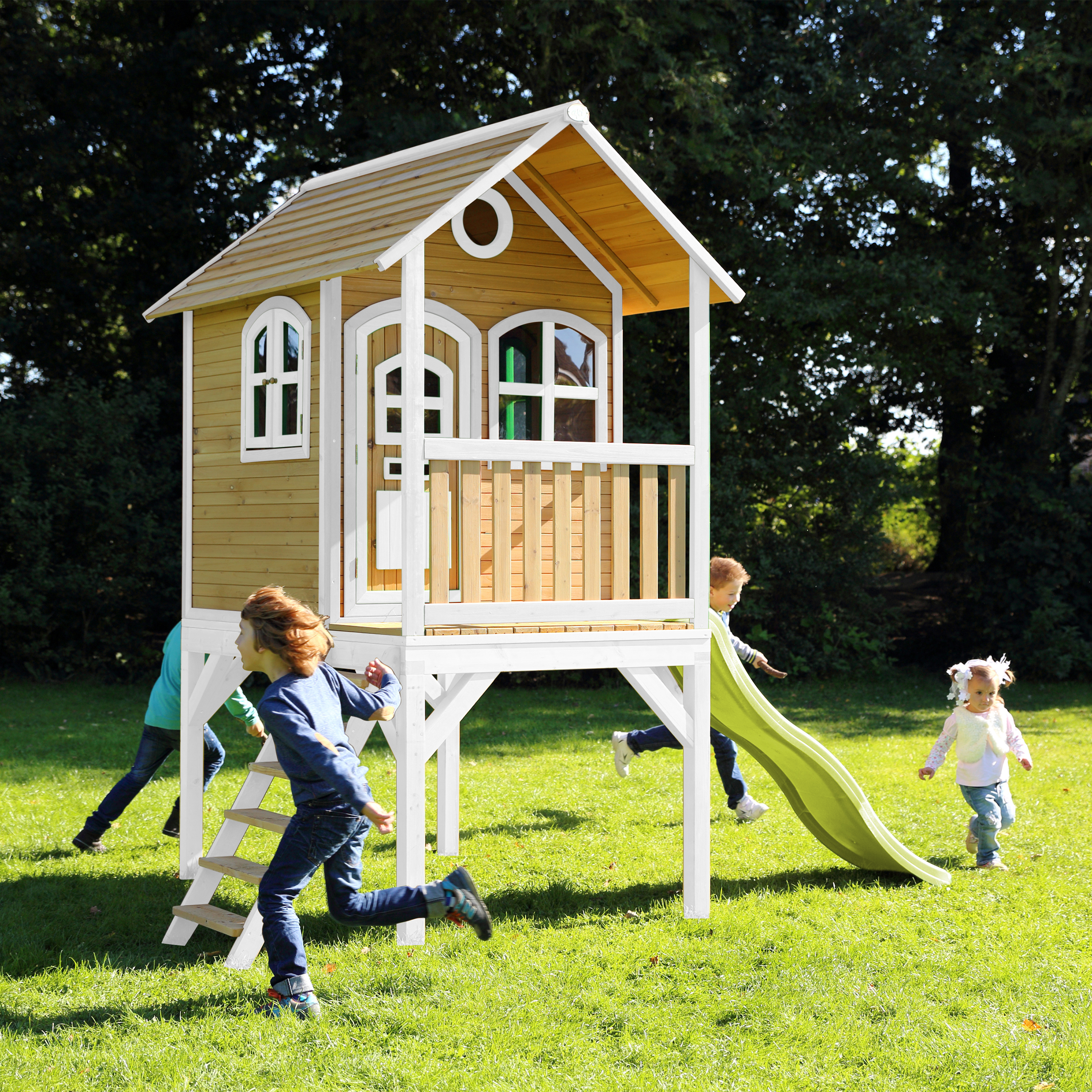Kinder spielen auf einem Spielhaus mit Rutsche und Leiter.