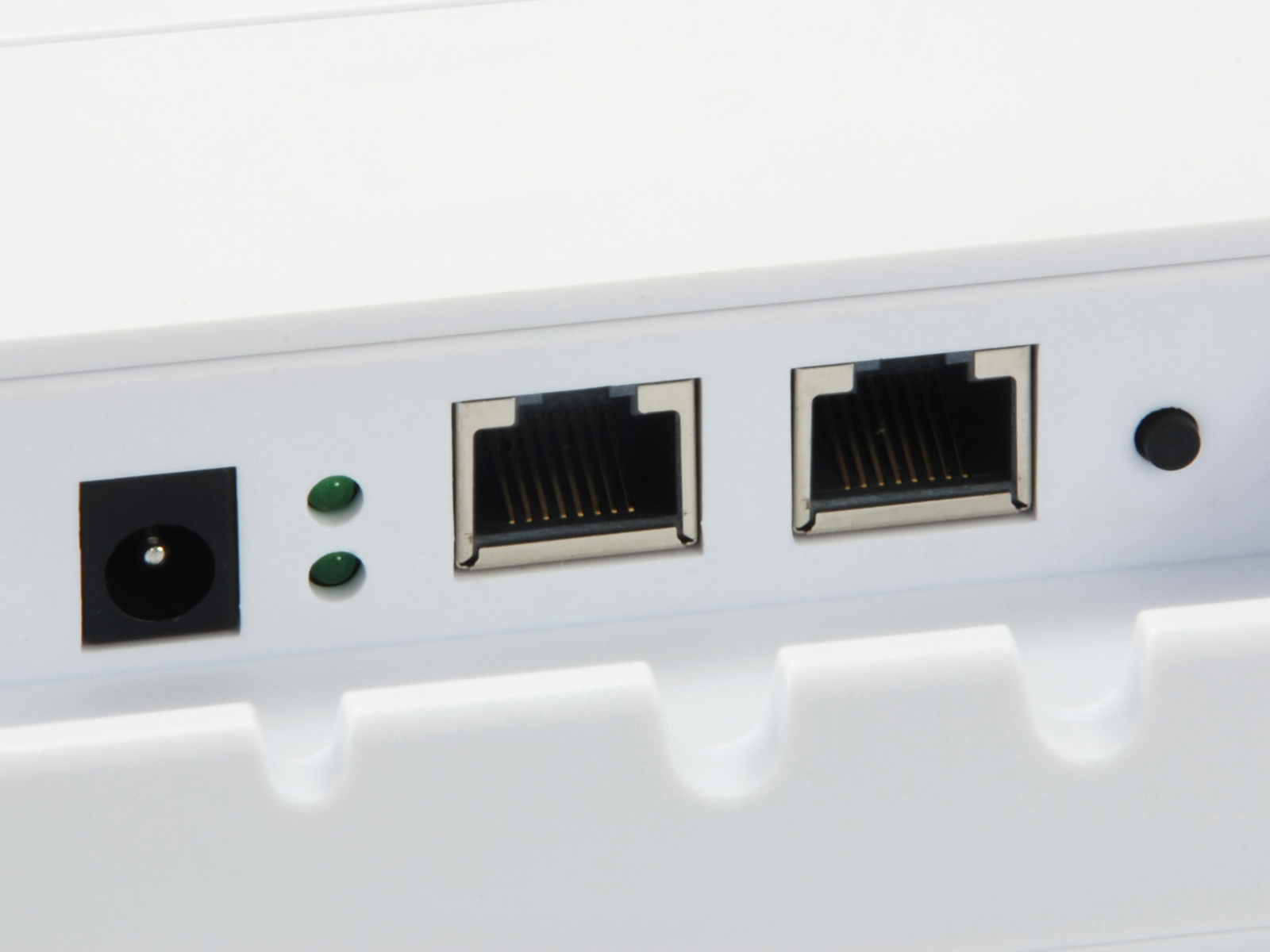 Primer plano de puertos de dispositivo blanco: alimentación, dos Ethernet y botón de reinicio.