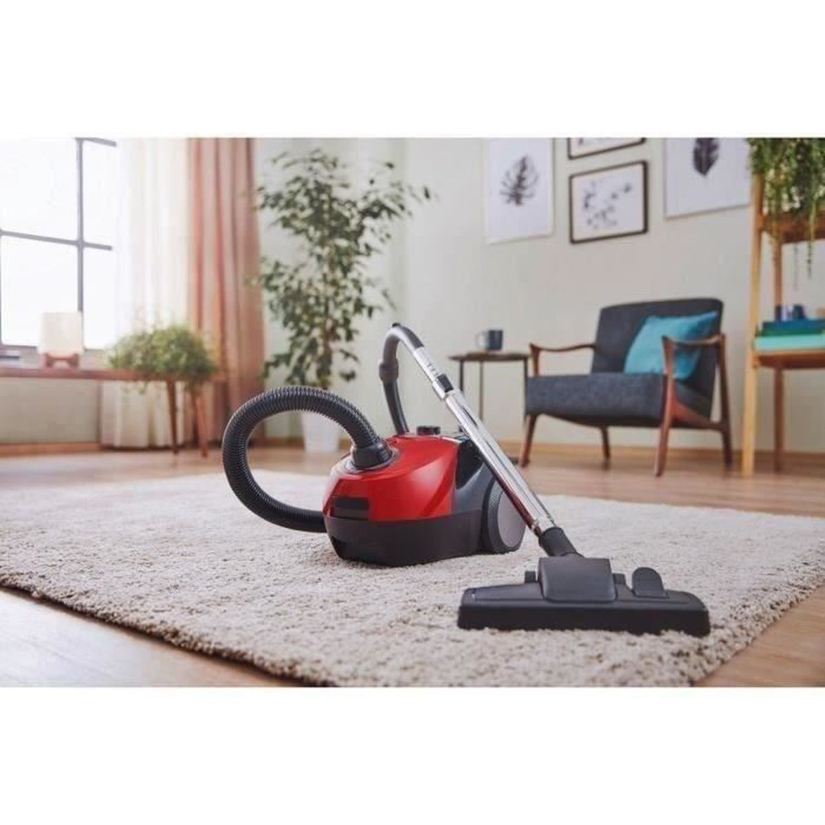 A red and black vacuum cleaner on a carpet in a living room setting.