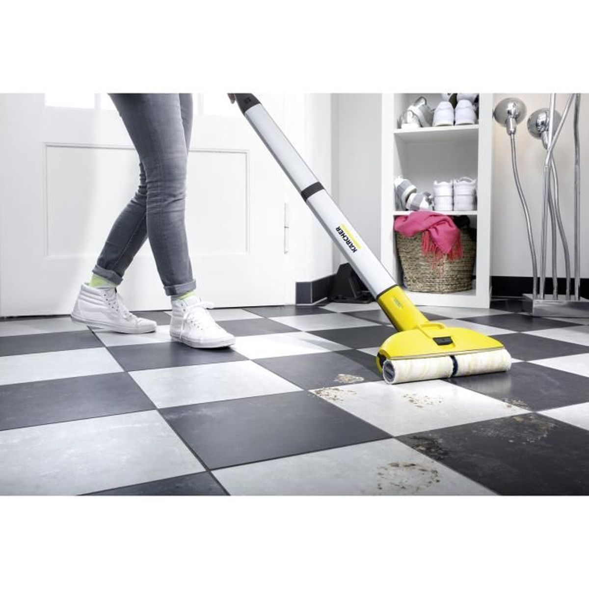 Una donna usa un pulitore per pavimenti giallo e bianco su piastrelle a scacchi.