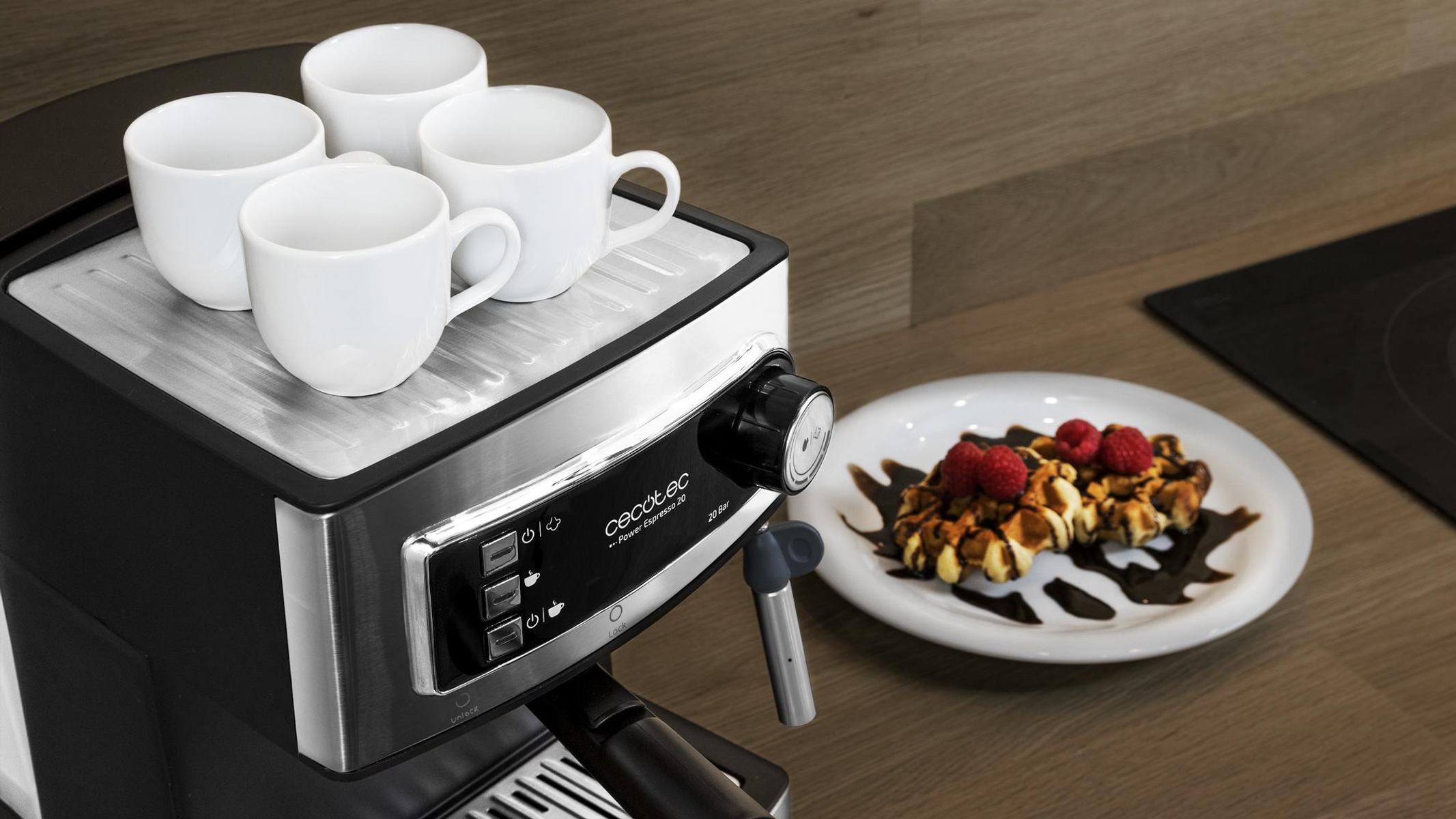 Una macchina per espresso con quattro tazze bianche e un piatto di waffle con guarnizioni.