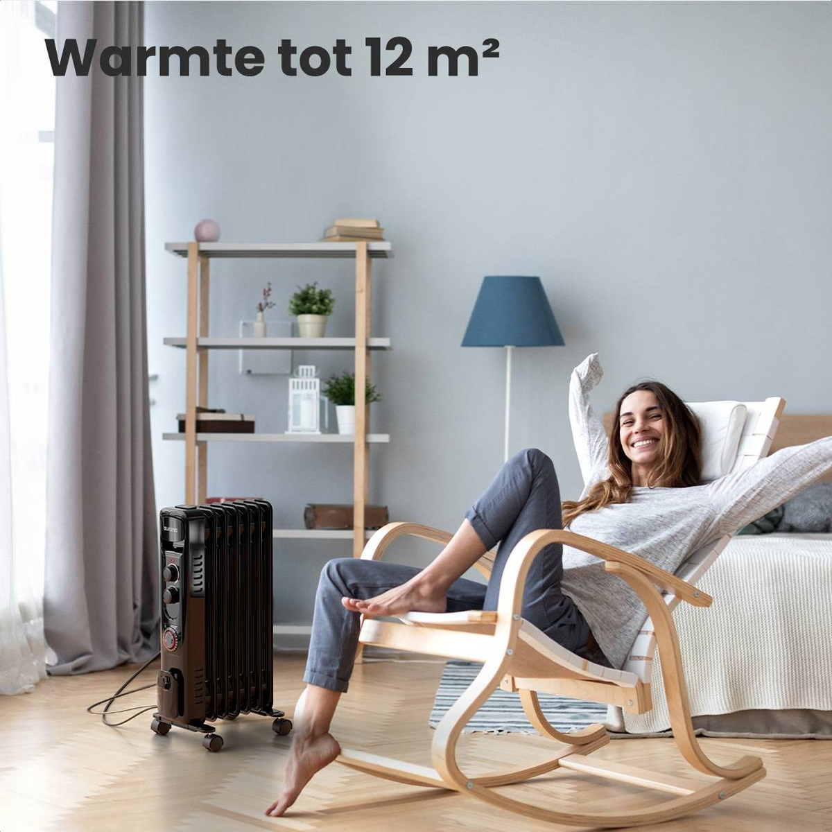 Eine Frau sitzt auf einem Schaukelstuhl, vor ihr steht ein Heizlüfter.