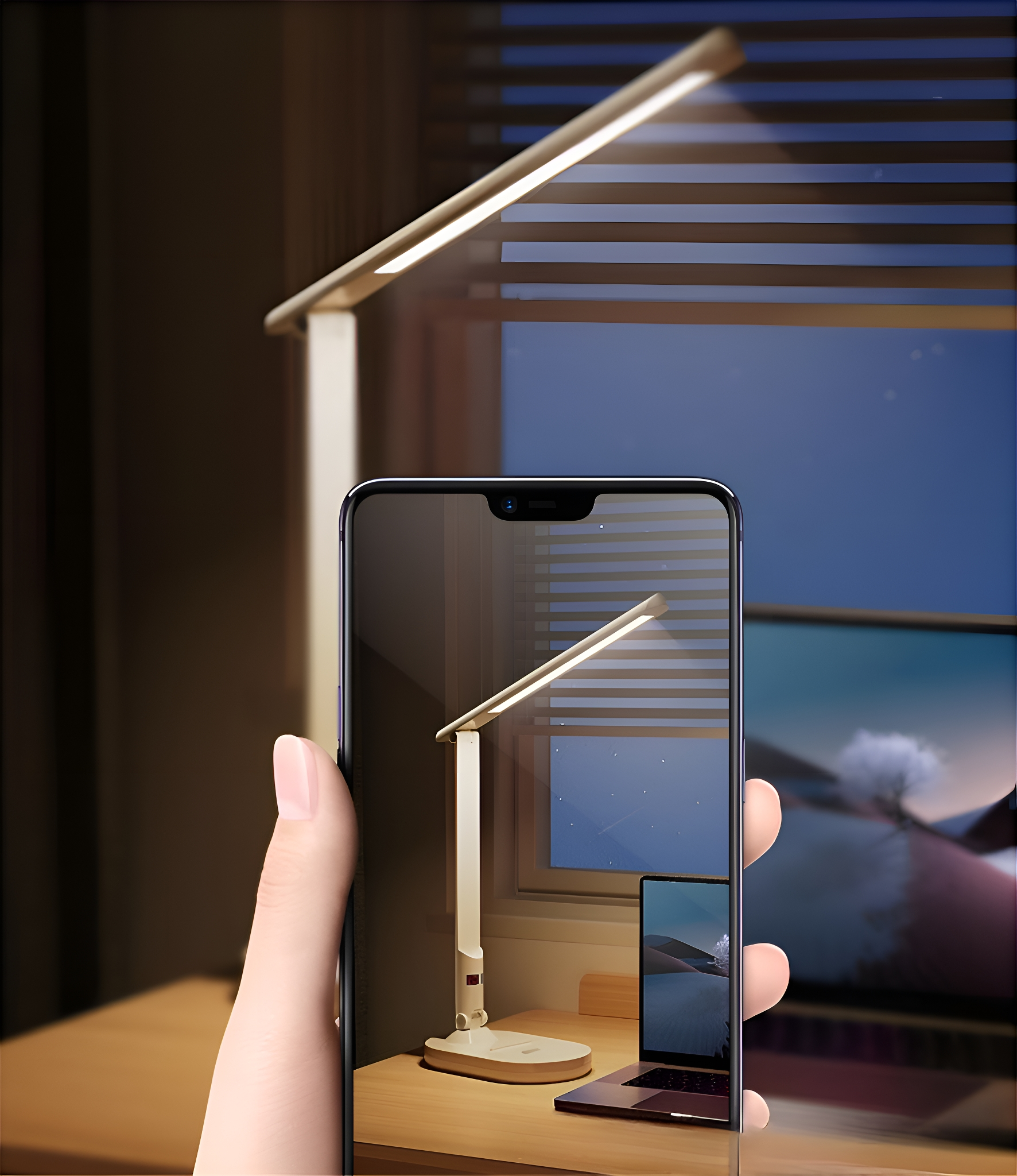 Eine Hand, die ein Telefon hält, das eine Lampe auf einem Schreibtisch zeigt. Die Lampe ist auch im wirklichen Leben, leuchtend.