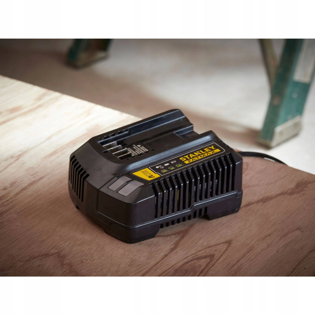 Cargador de batería Stanley Fatmax 20V negro y amarillo sobre madera.