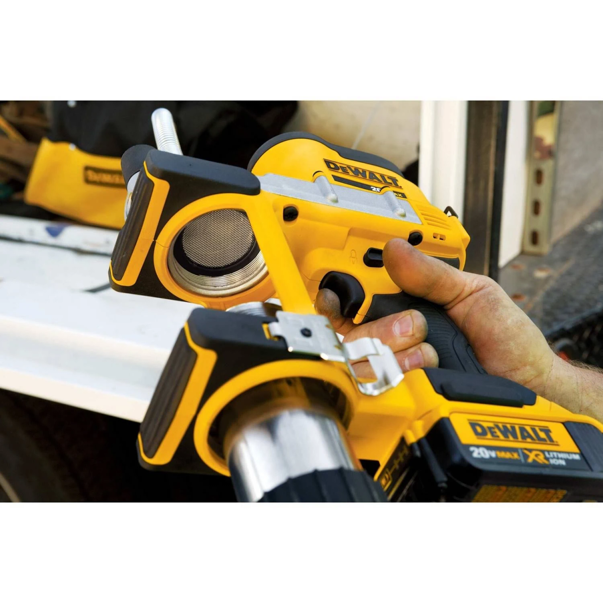 Utensile elettrico DeWalt giallo e nero tenuto in mano. L'utensile ha un ugello e una batteria.