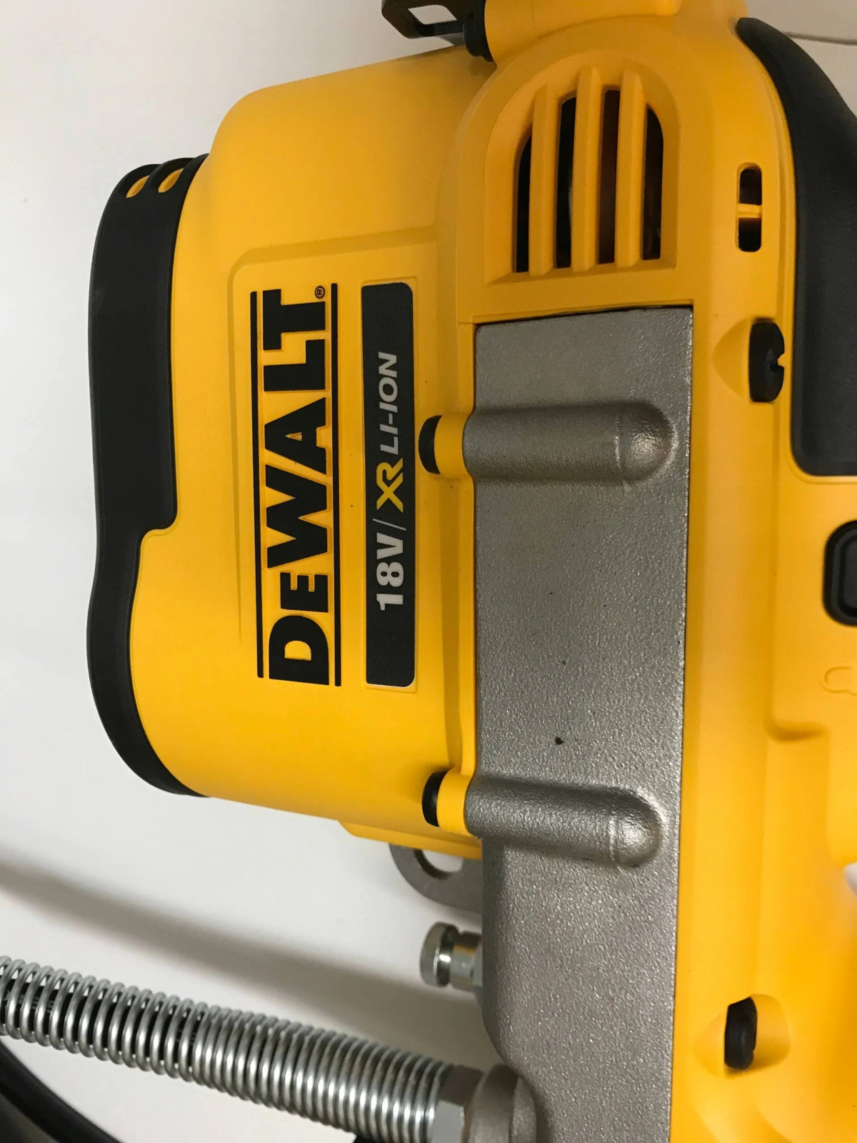 Un utensile DeWalt 18V XR Li-Ion giallo e nero, vista laterale, contro un muro bianco.