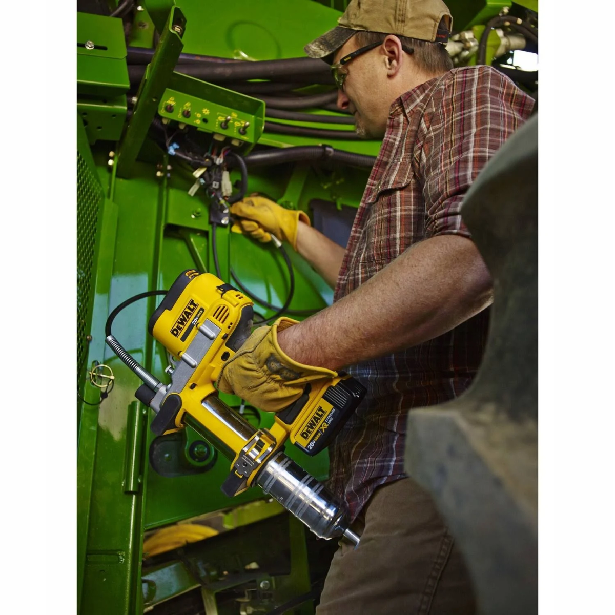 Uomo che usa un utensile elettrico Dewalt giallo e nero su una macchina verde. Guanti gialli.