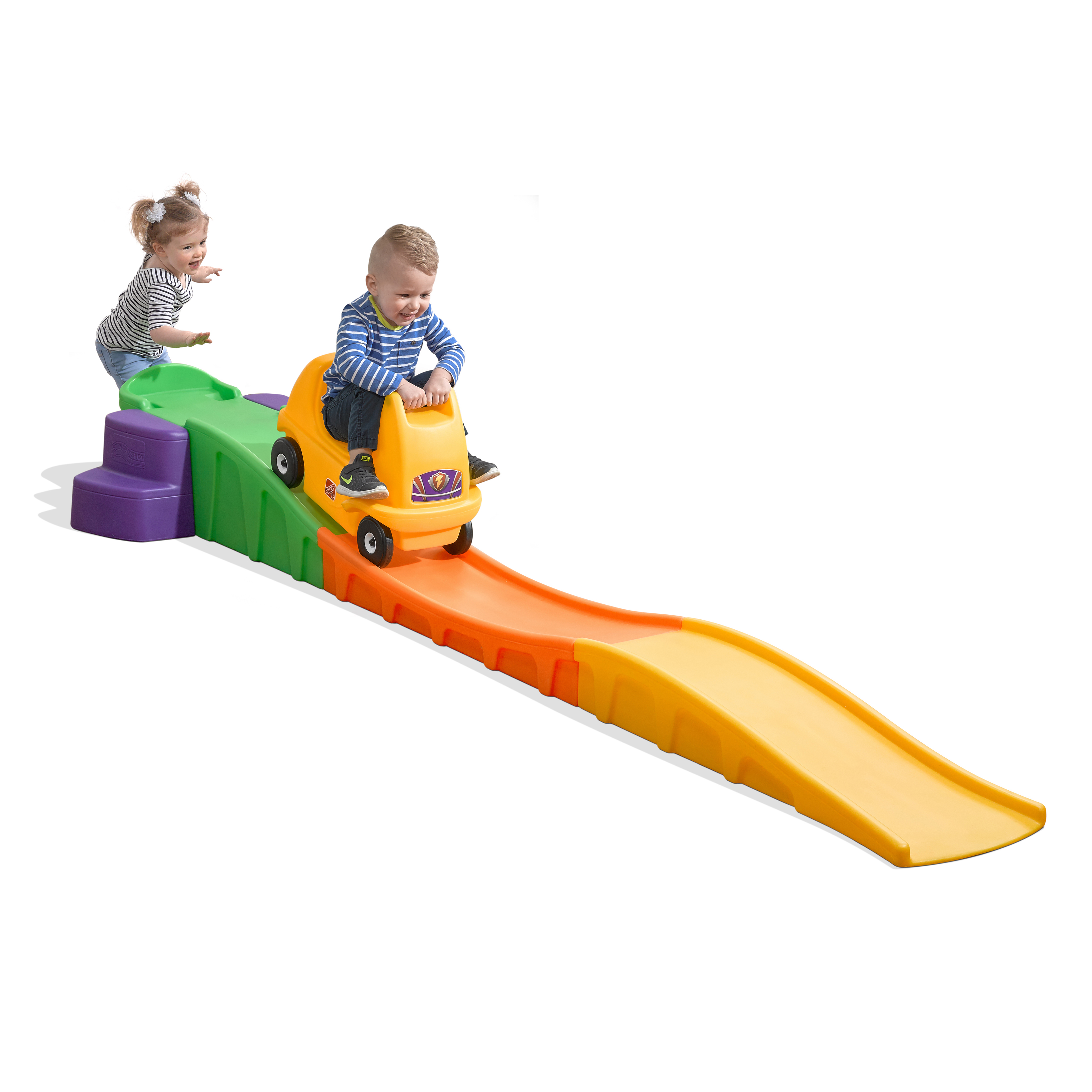Kinder auf einem gelben Spielzeugauto auf einer bunten Strecke, mit einer Rampe.
