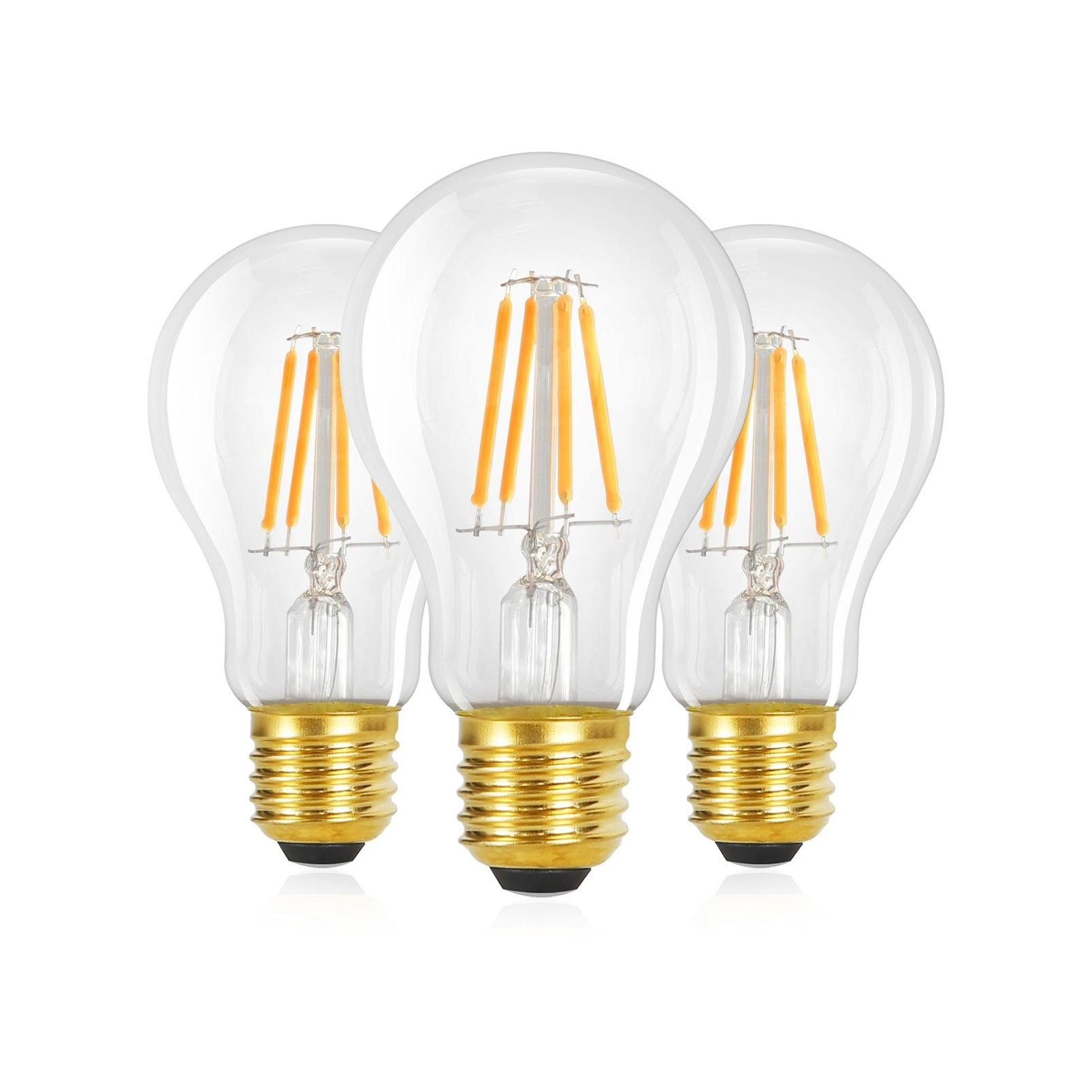 Tre lampadine trasparenti con base dorata su sfondo bianco.