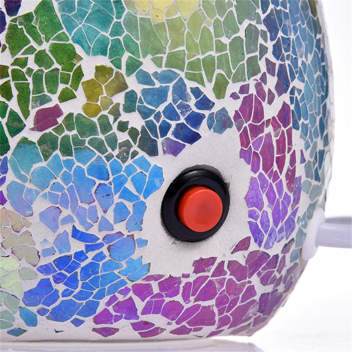 Nahaufnahme einer Mosaiklampe mit rotem Knopf. Buntes, künstlerisches Design.