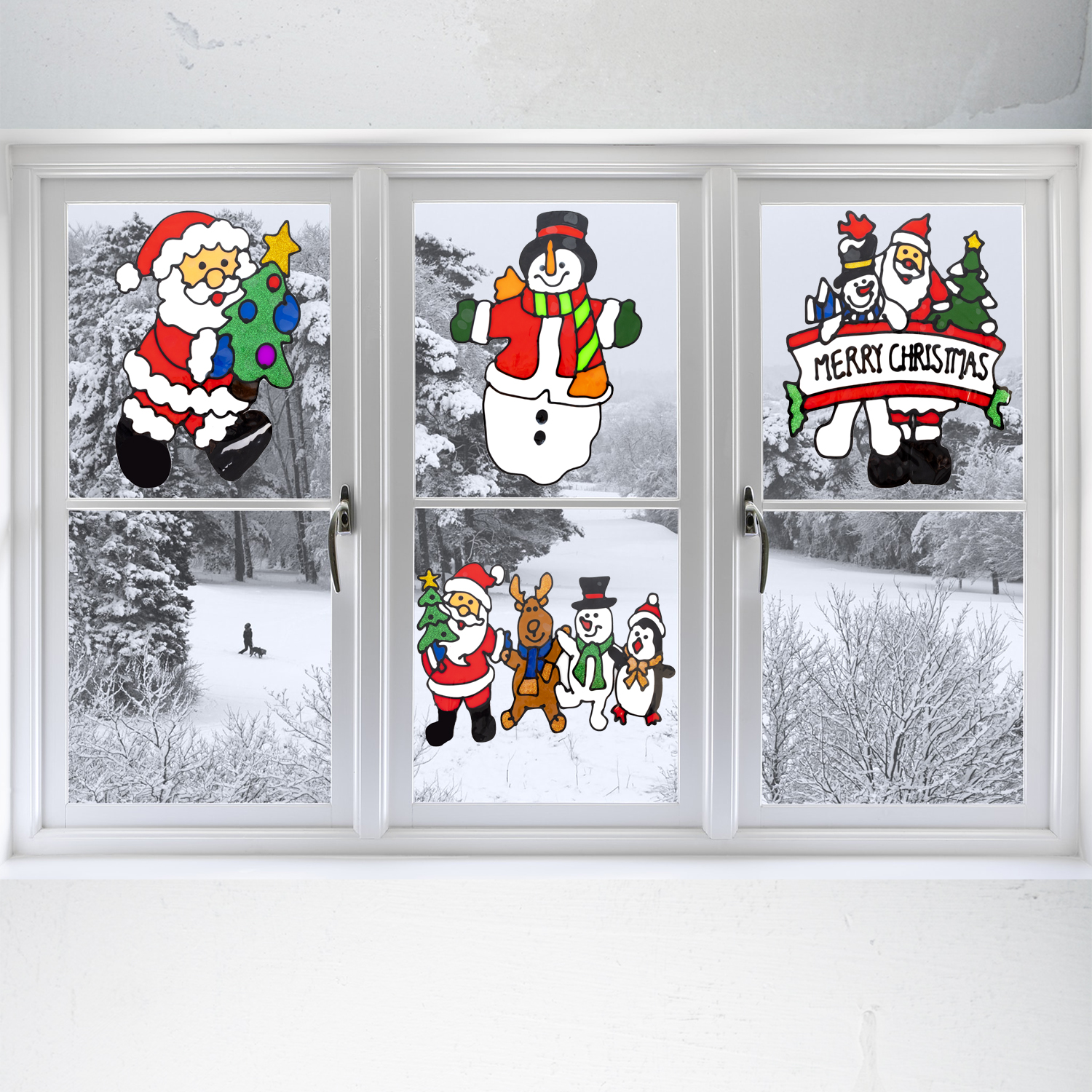 Drei Fenster mit Weihnachtsdekorationen: Weihnachtsmann, Schneemann und ein Banner mit 'Merry Christmas'.