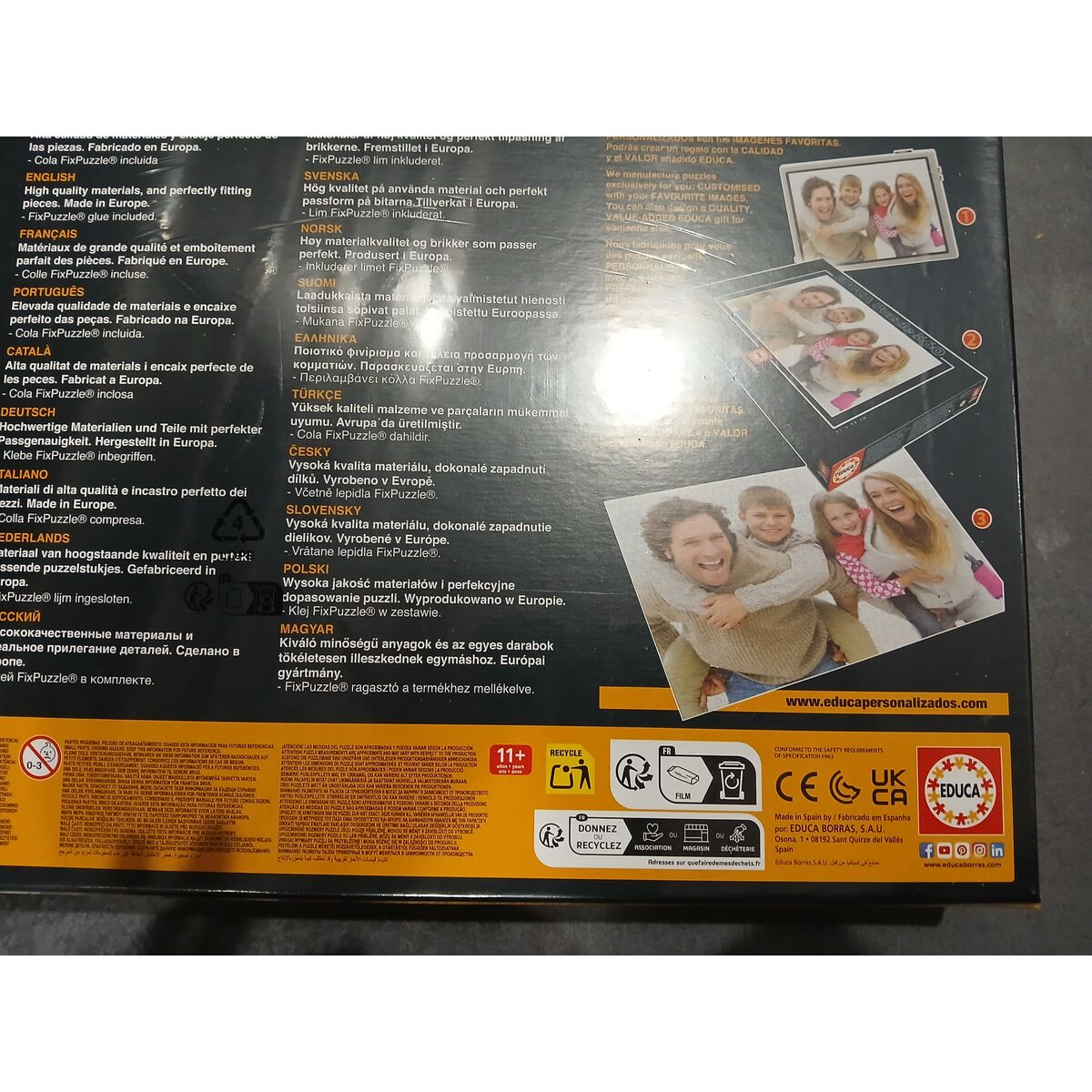 Schachtel mit Familienfoto-Puzzle. Text in mehreren Sprachen, Recycling-Symbole vorhanden.