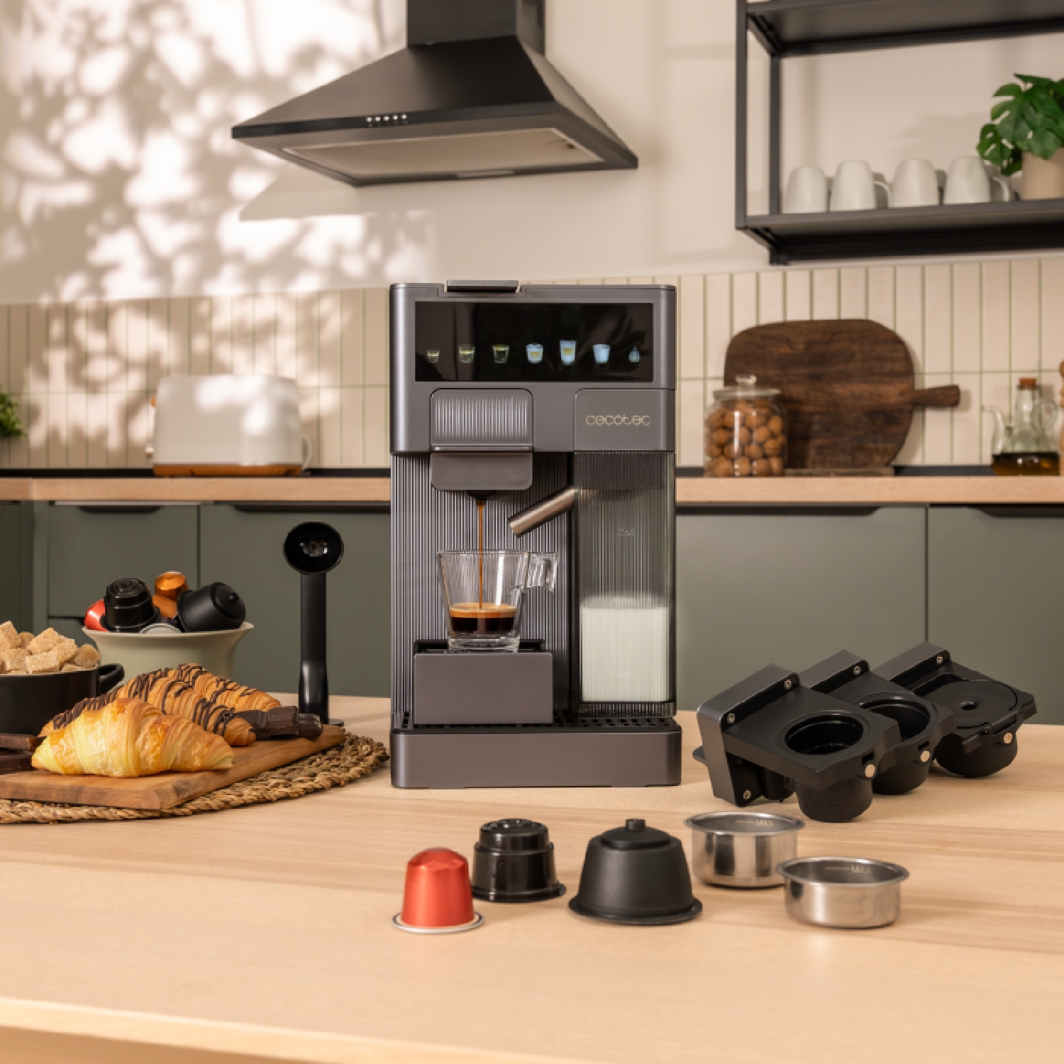 Macchina da caffè che versa caffè in un bicchiere. Croissant e cialde su tavolo di legno.