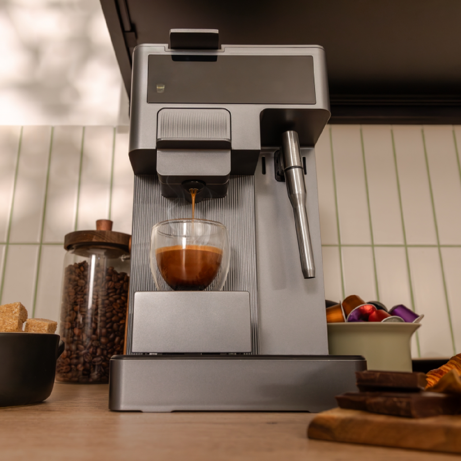 Macchina da caffè con caffè versato in un bicchiere. Chicchi di caffè in un barattolo.