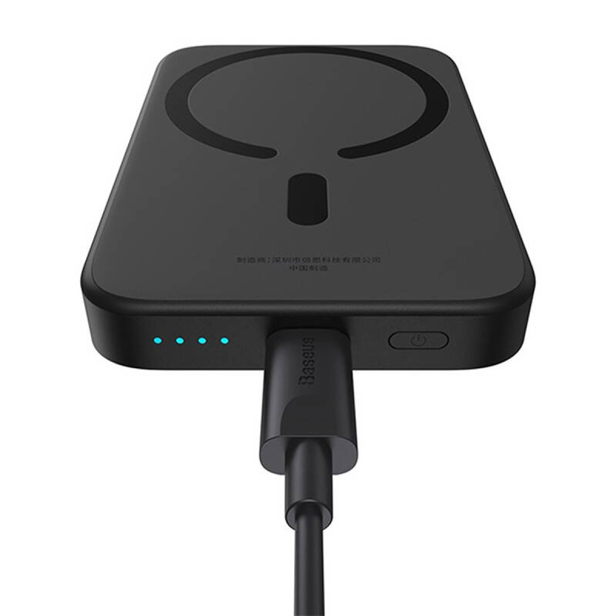 Schwarzes kabelloses Ladegerät mit kreisförmigem Design. Ein Ladekabel ist eingesteckt.