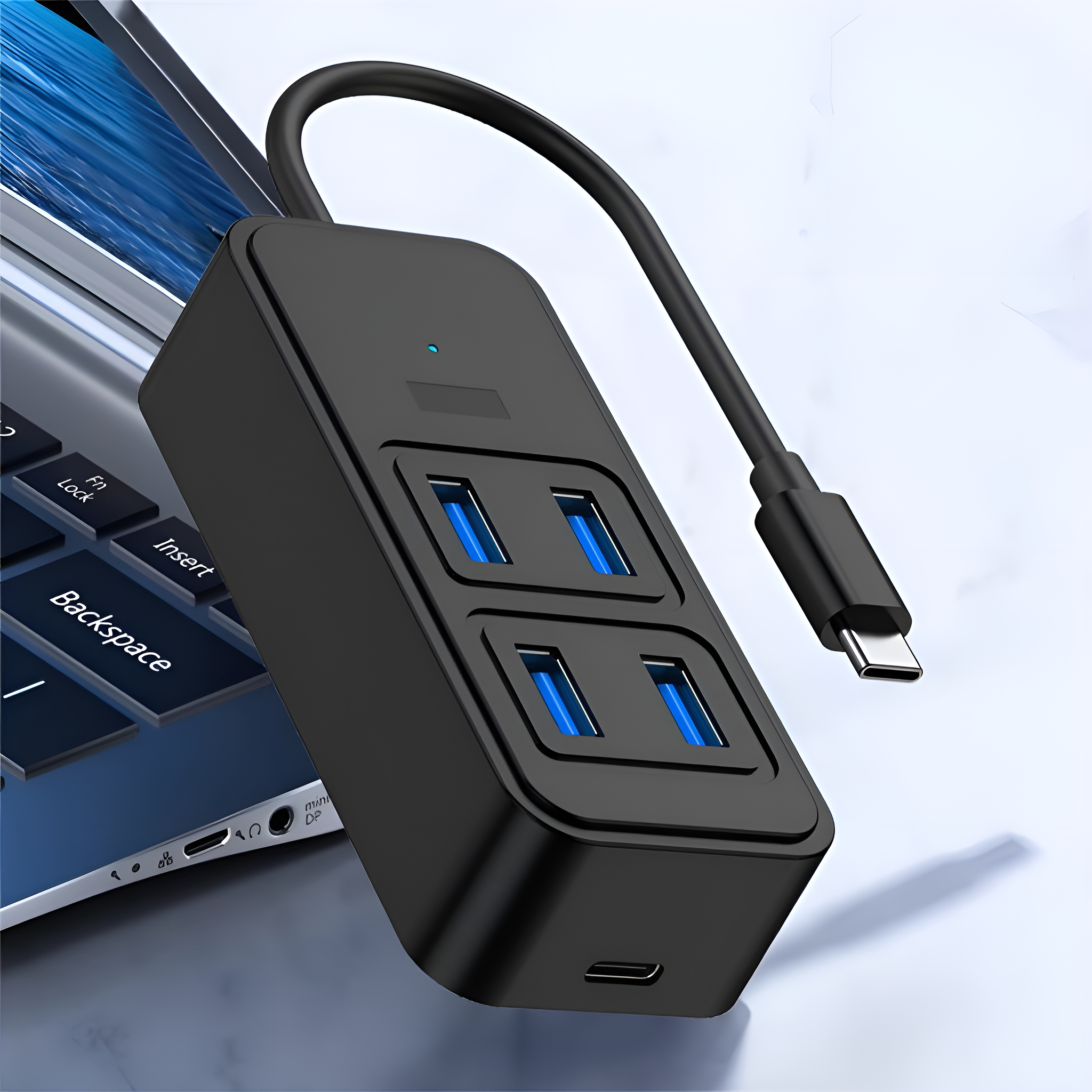 Schwarzer USB-Hub mit vier blauen USB-Anschlüssen, an Laptop angeschlossen.