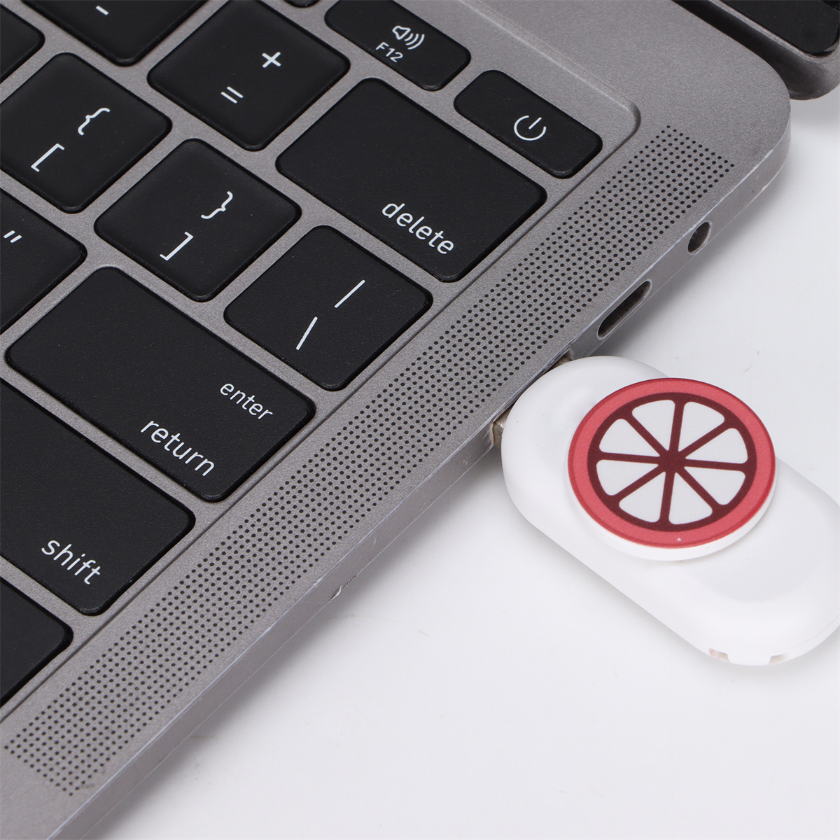 Laptop-Tastatur mit eingestecktem USB-Laufwerk; das Laufwerk hat ein rot-weißes Design.
