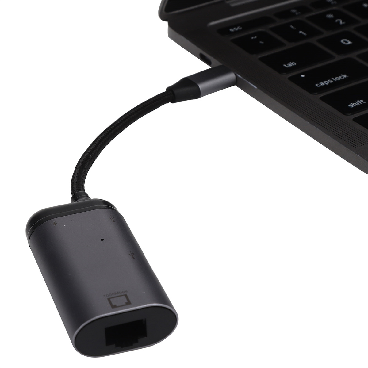 Ein grauer Adapter ist an einen Laptop angeschlossen. Es hat ein schwarzes Kabel und einen Anschluss für ein Ethernet-Kabel.