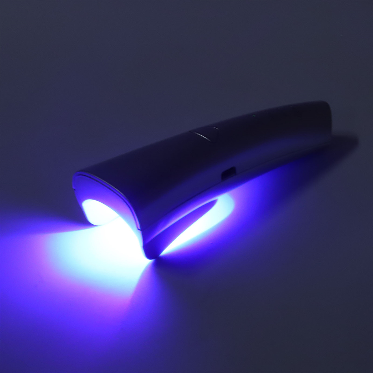 Ein graues Gerät, das blaues Licht aussendet. Das Licht ist unten konzentriert.