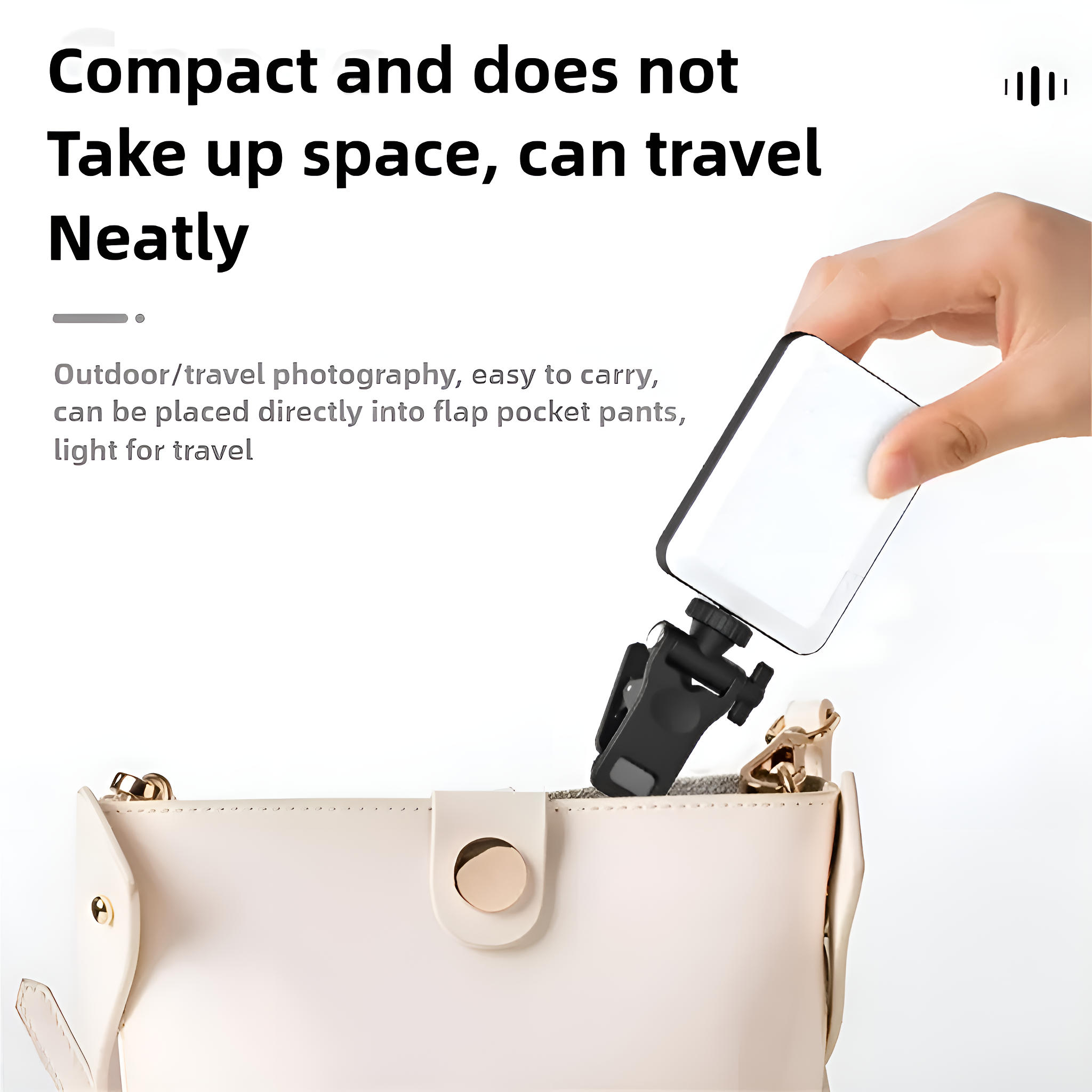 Hand hält kleines weißes Licht mit schwarzem Clip, über einer Handtasche.